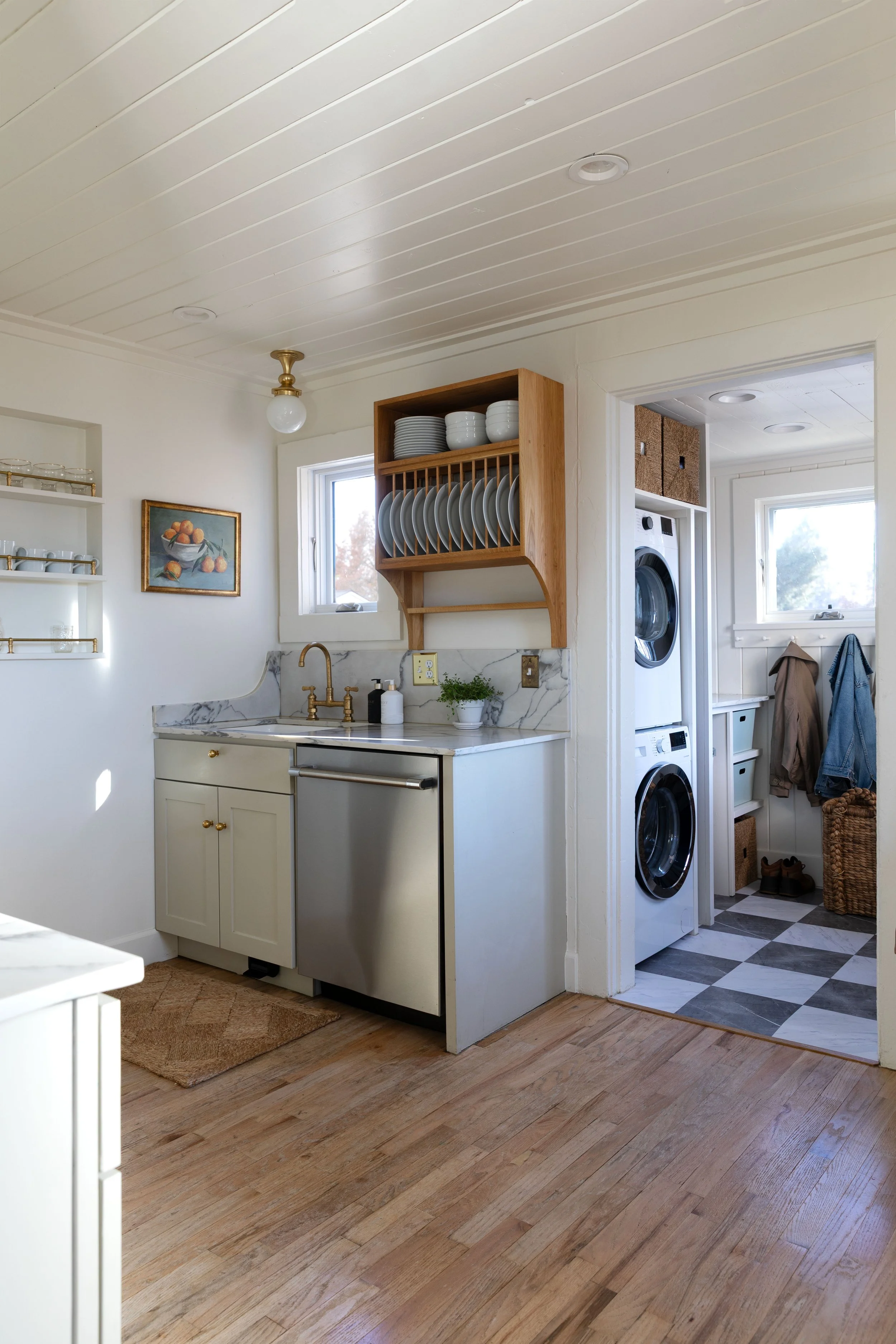 Kitchen layout view showing sink wall, plate rack, and mudroom beyond.