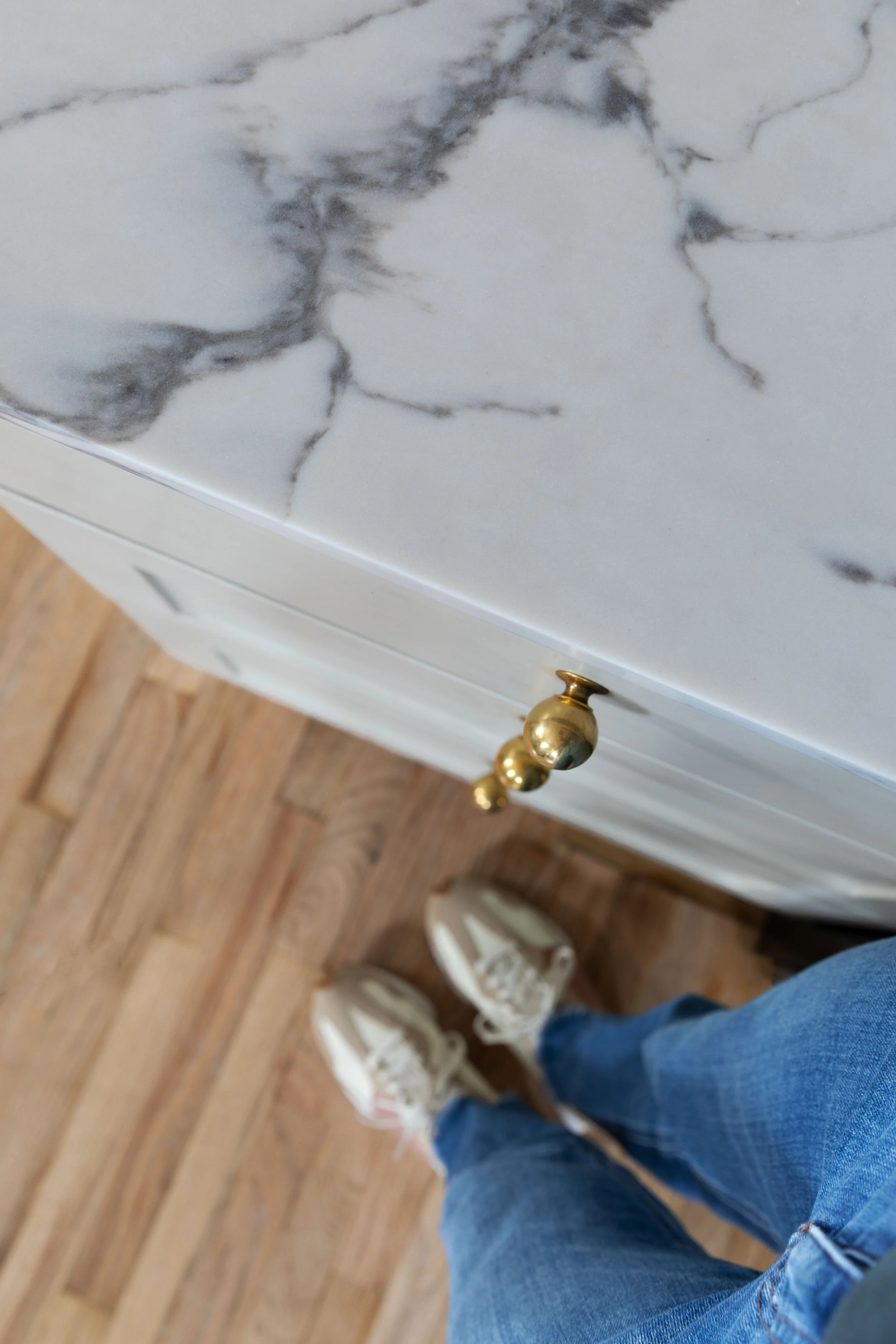 Overhead view of quartz countertop with brass hardware and fir floors.