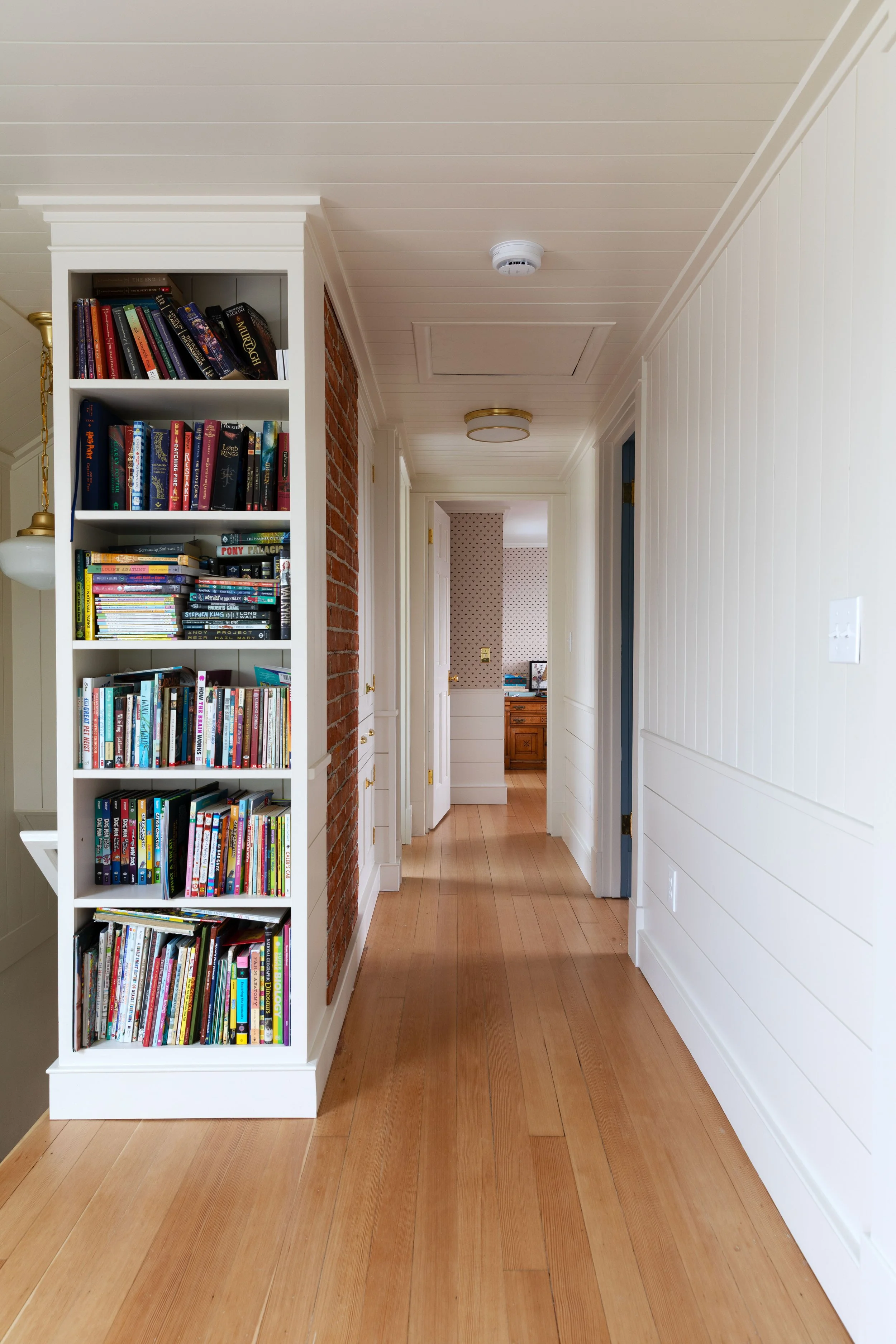 Built-in bookcase beside the stairs in the renovated upstairs hallway