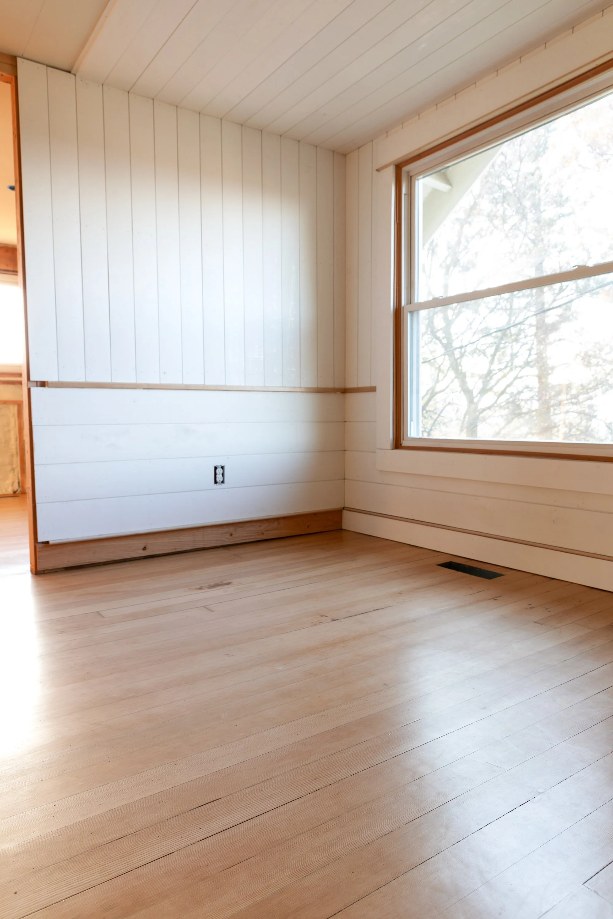 Finished fir wood floors at the Hill House with natural light, paneled walls, and classic details