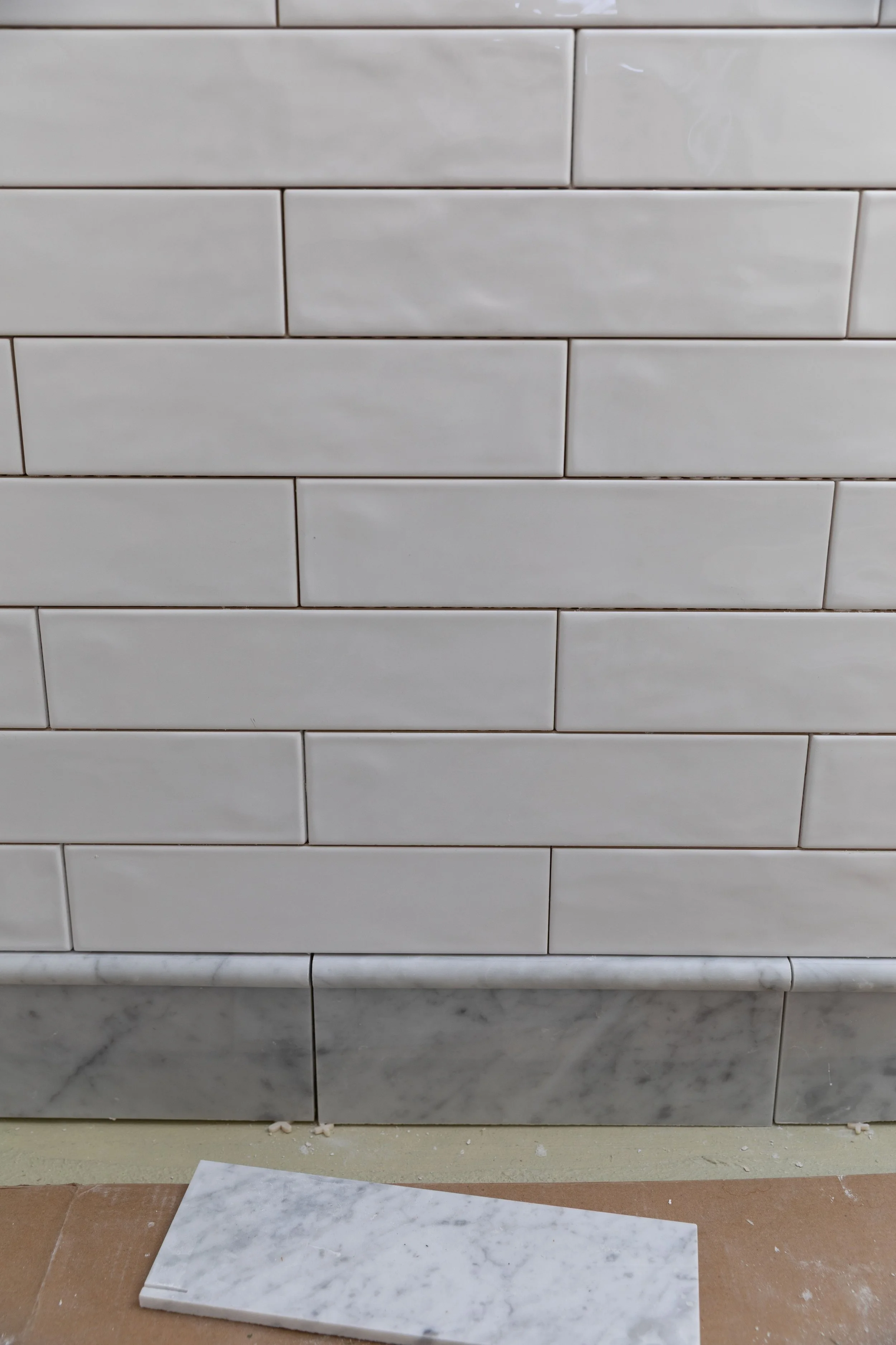 Using white subway tile and a marble base in the bathroom
