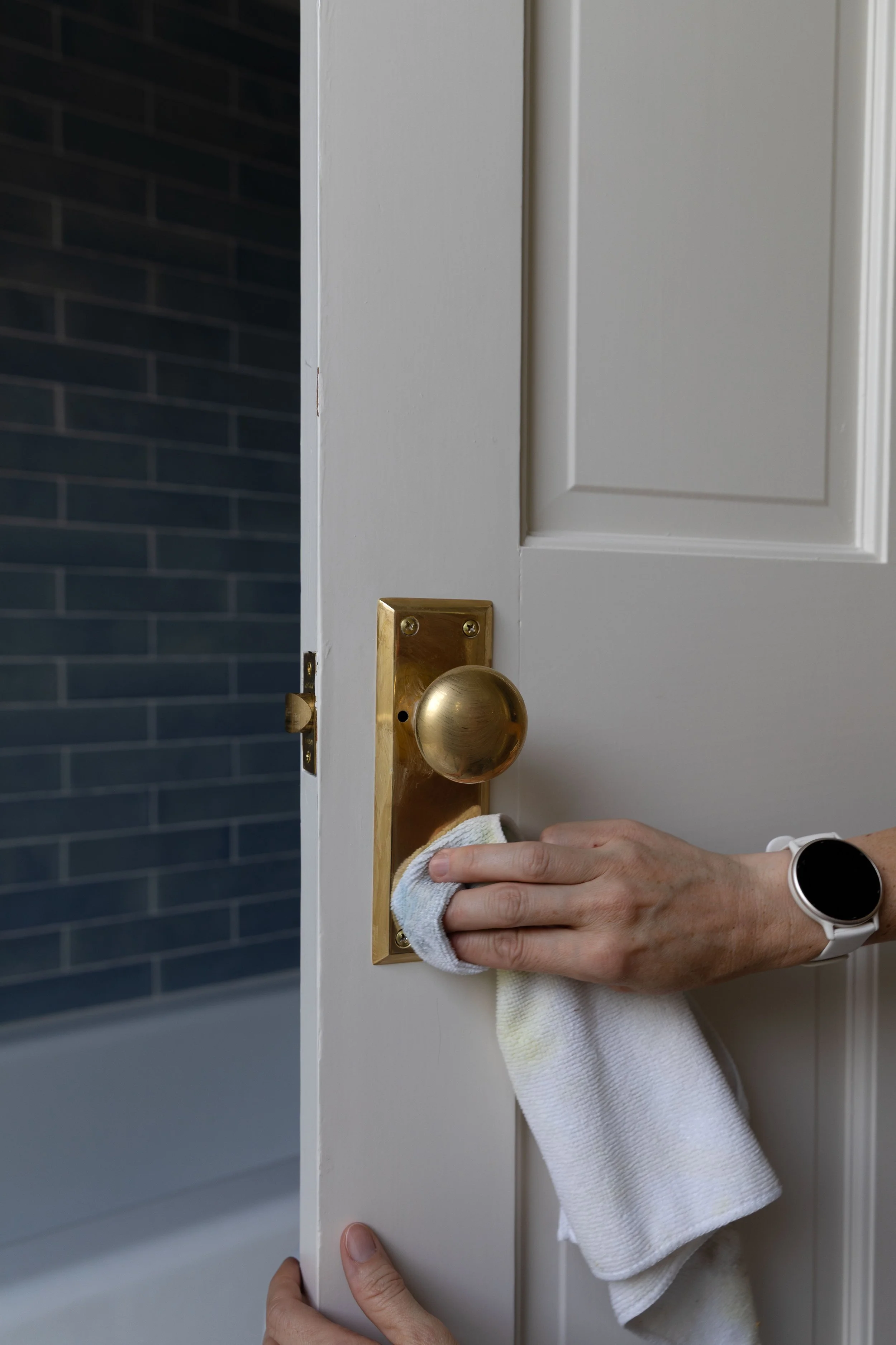 Brasso forming a hazy film on an unlacquered brass doorknob during polishing