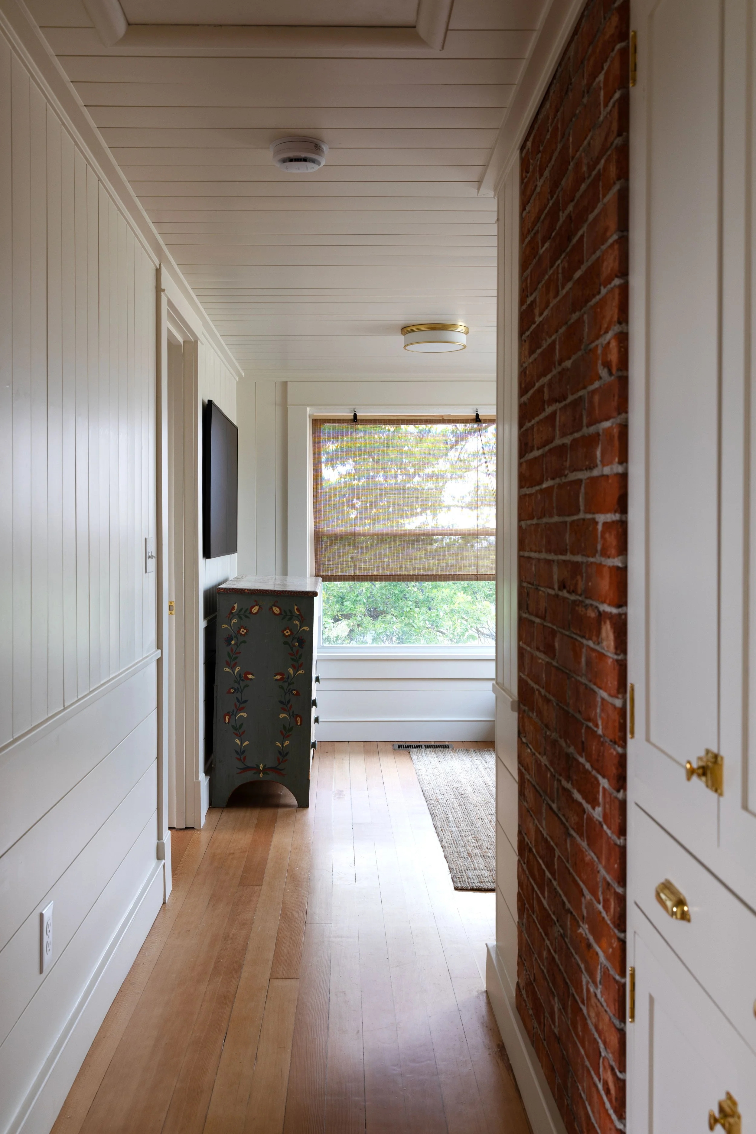 Renovated paneled upstairs hallway opening into the small Hill House snug