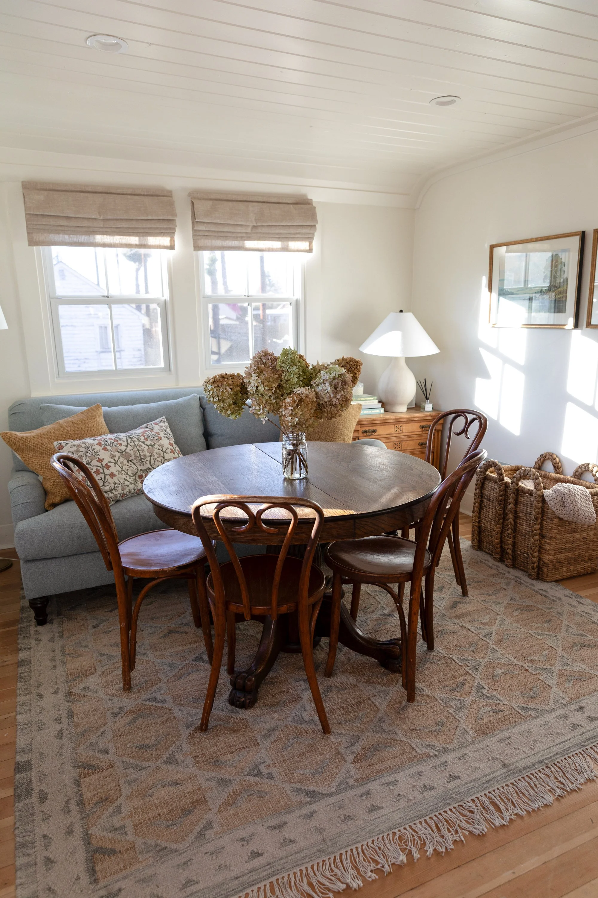 Looking down on vintage round dining table with hydrangeas in the Poplar Cottage sitting and dining room