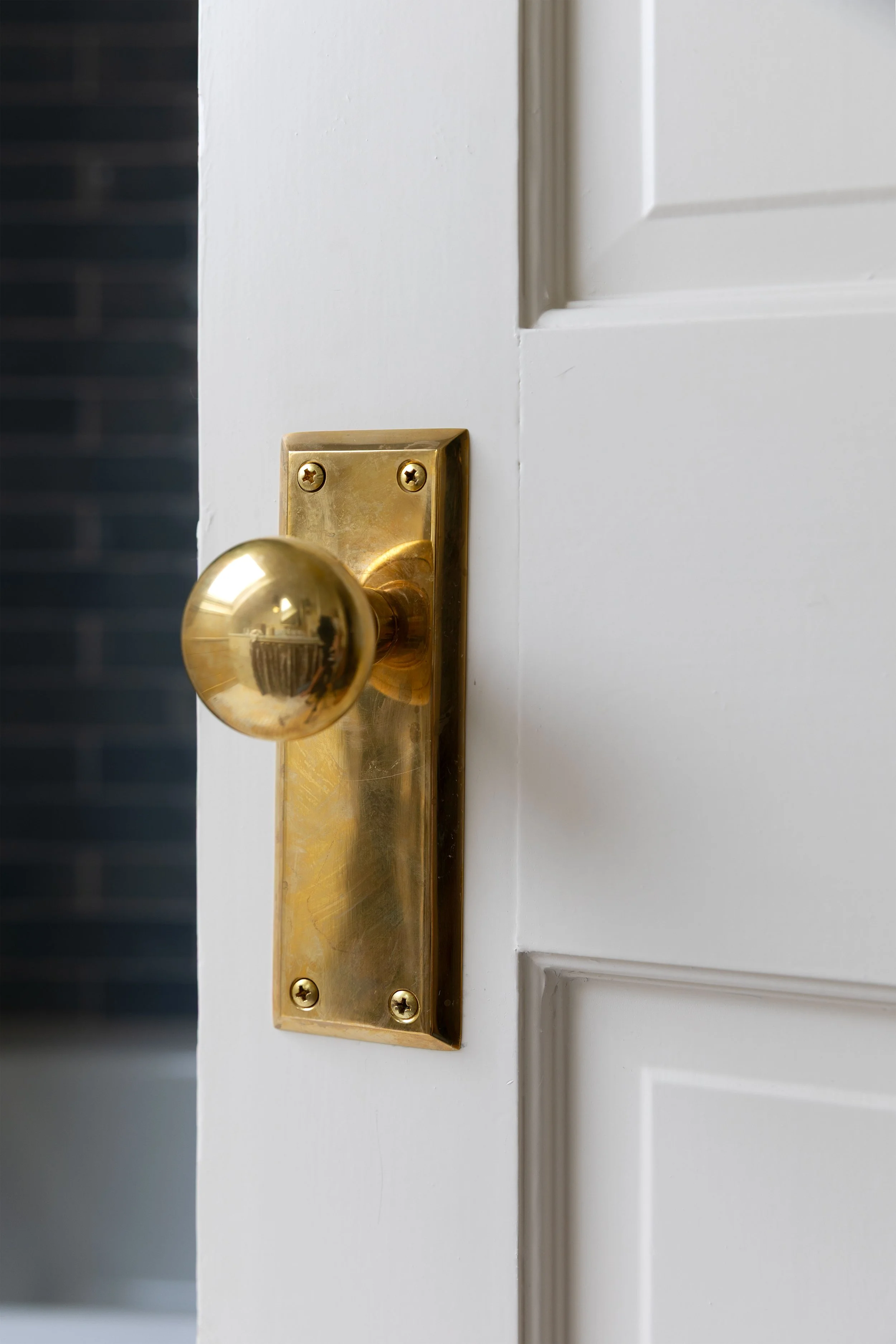 Unlacquered brass doorknob with several years of natural patina and darkened wear