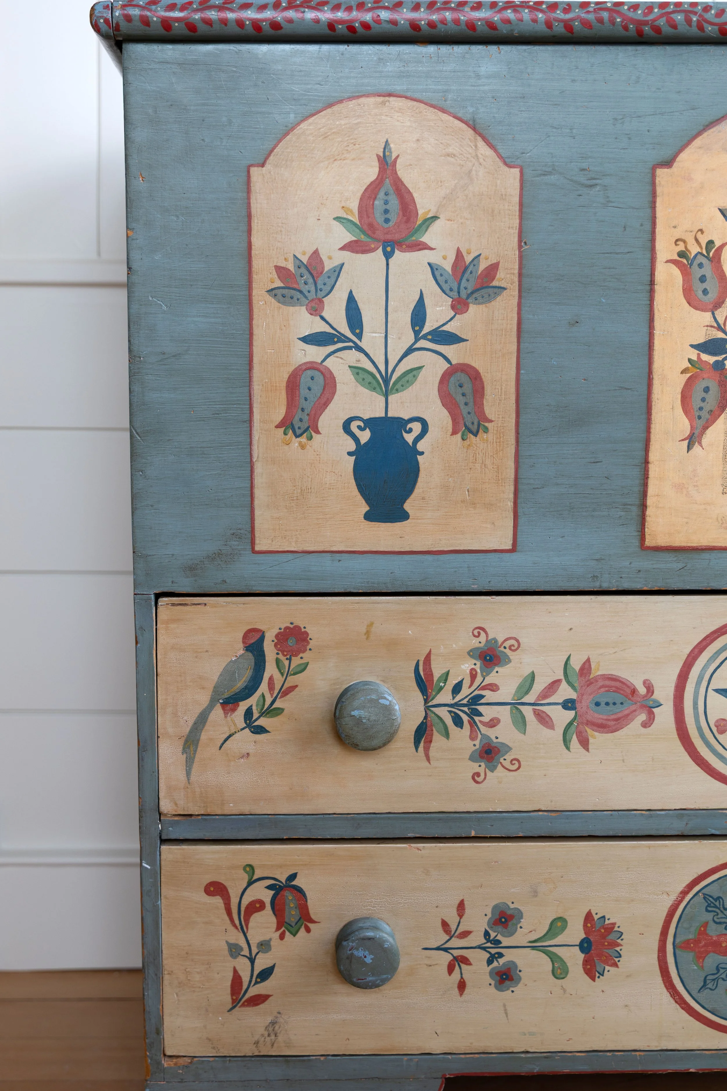 Close up of a hand-painted dresser with floral motif and birds