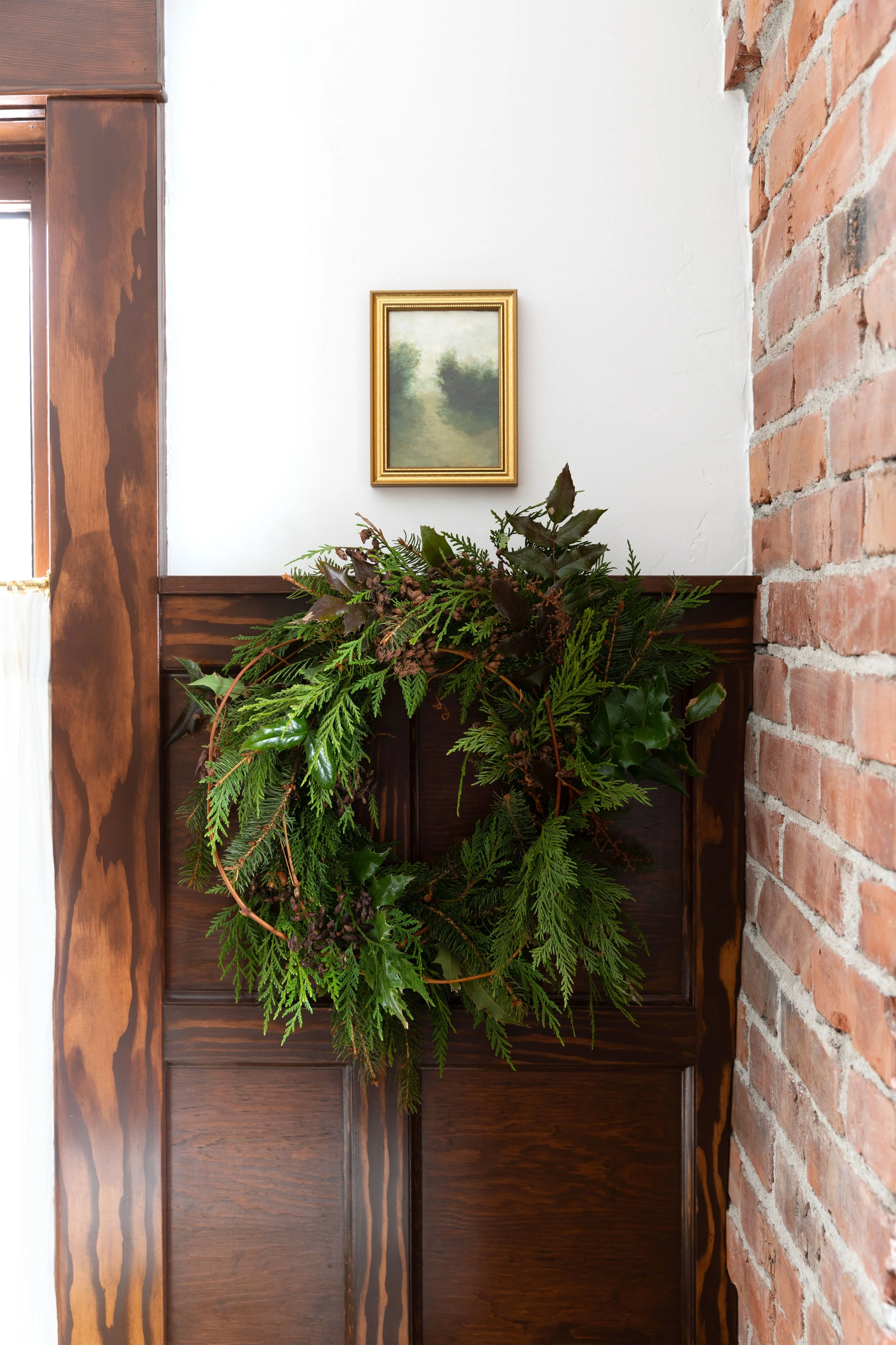 Classic farmhouse bathroom decorated for Christmas with evergreen wreath — timeless holiday decor inspiration.