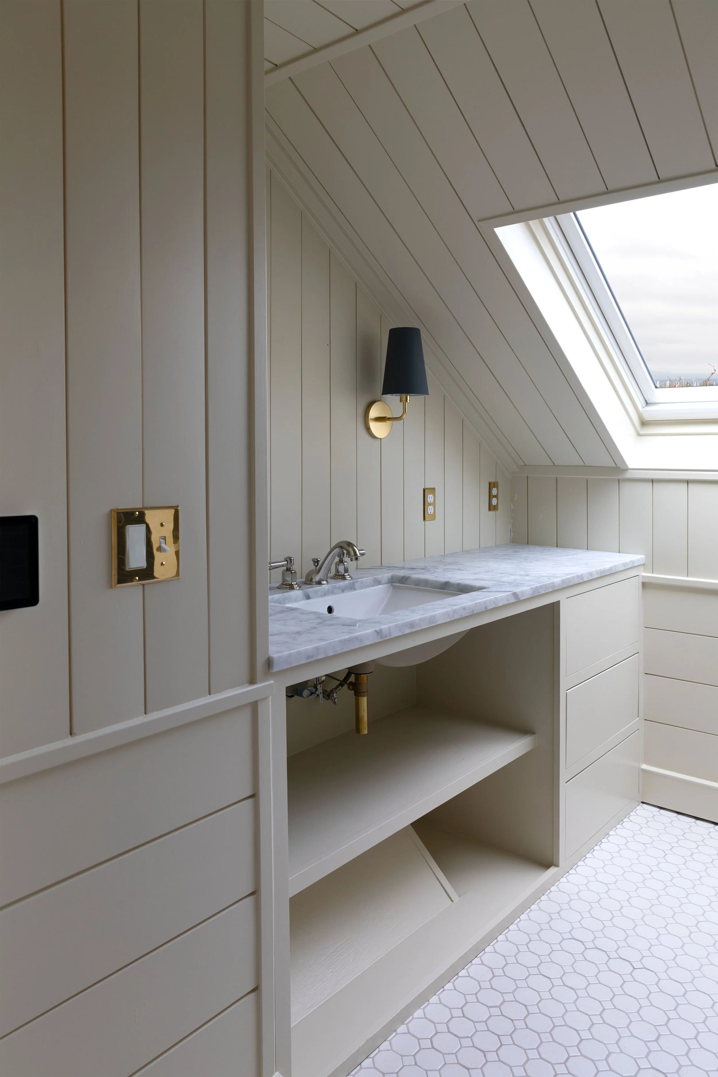 Paneled walls and sloped ceilings in the Hill House renovation hall bathroom