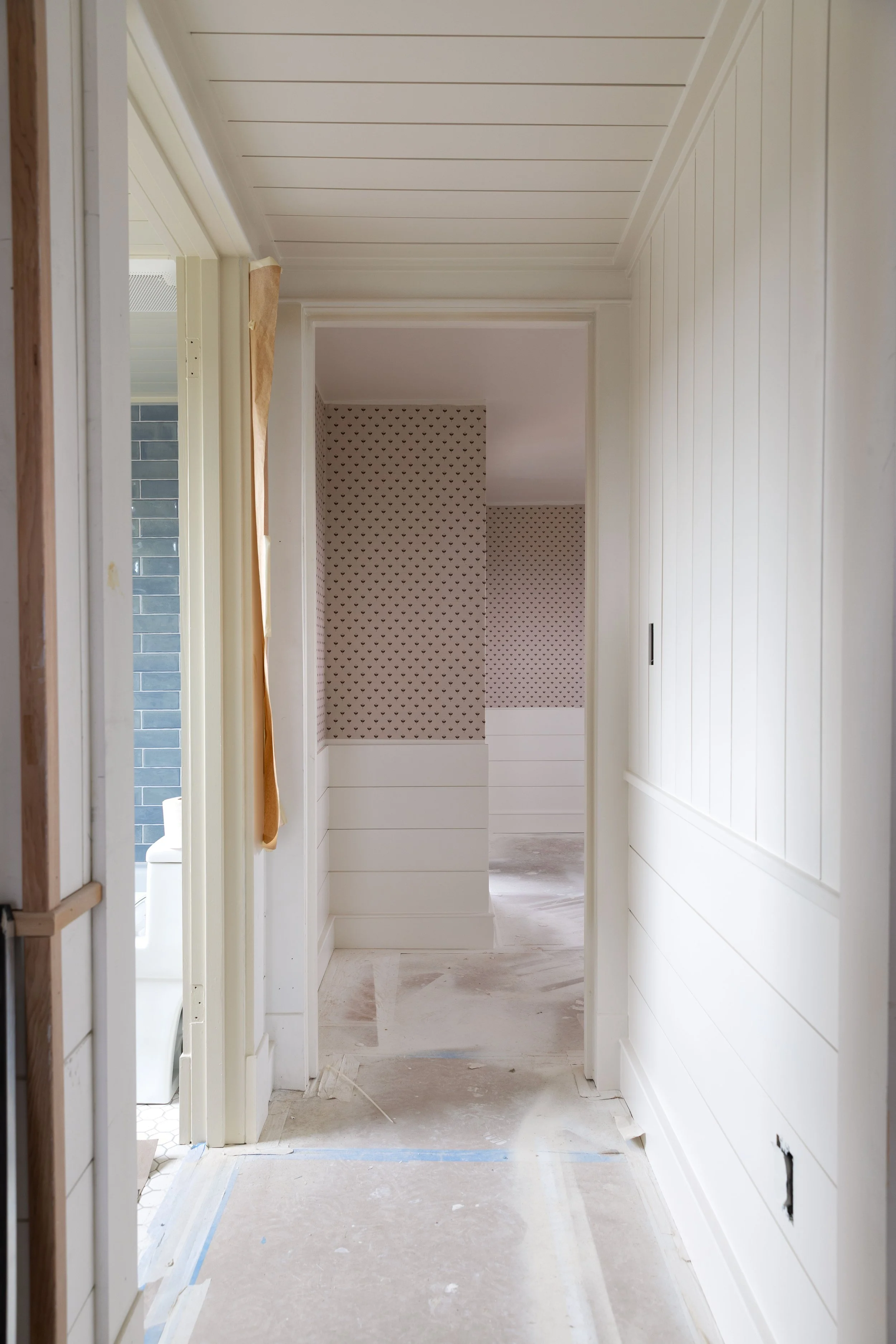 View from hallway into Daphne’s bedroom featuring newly installed grasscloth wallpaper