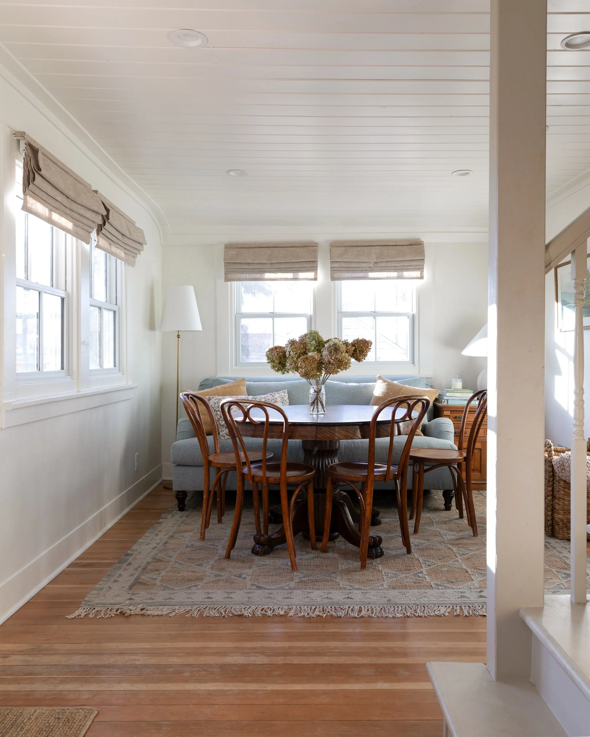 View from kitchen into the sitting and dining room showing new staircase and dining area filled with natural light