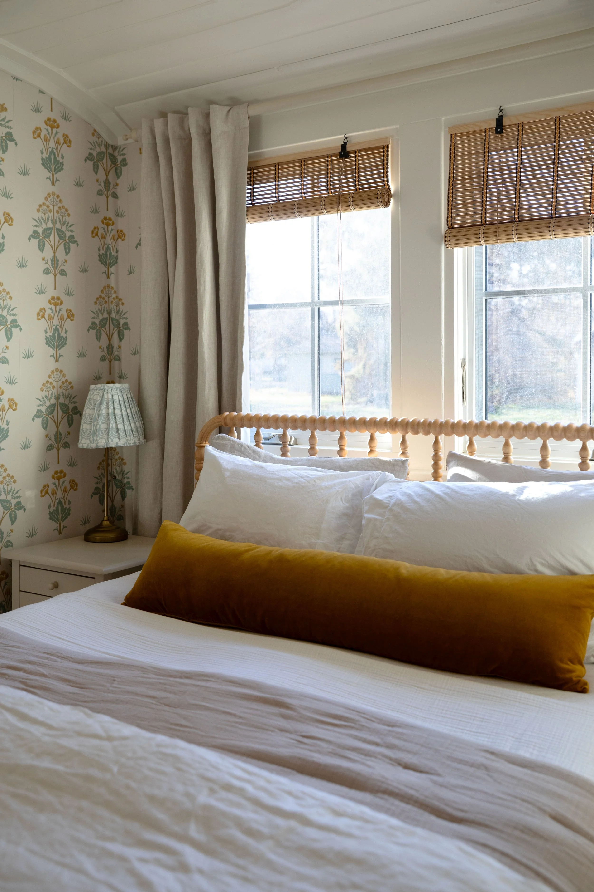 Jenny Lind bed styled with layered cotton bedding and a velvet lumbar pillow in the Poplar Cottage