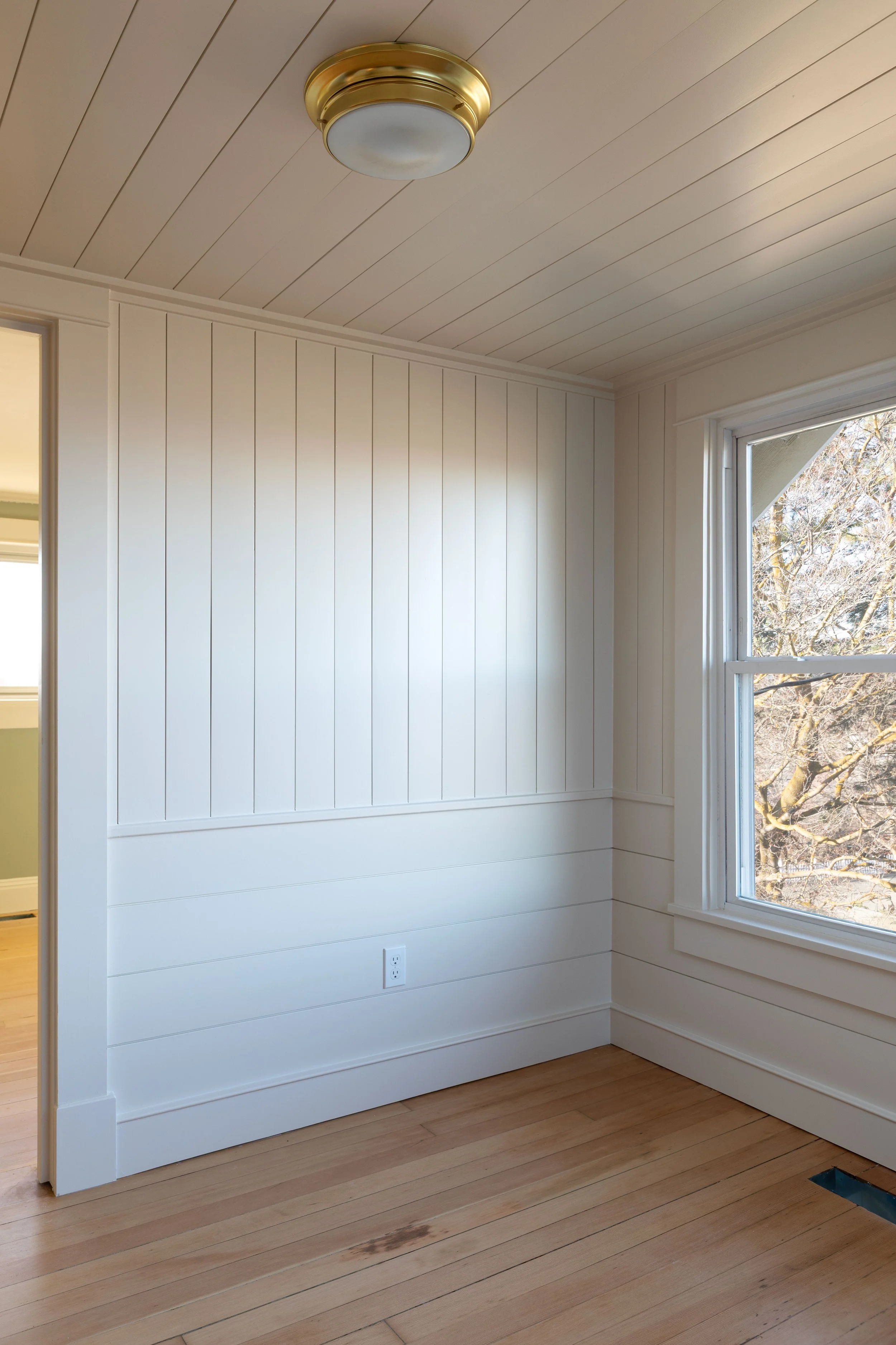 Nickel gap wall paneling with horizontal wainscot below in Hill House renovation