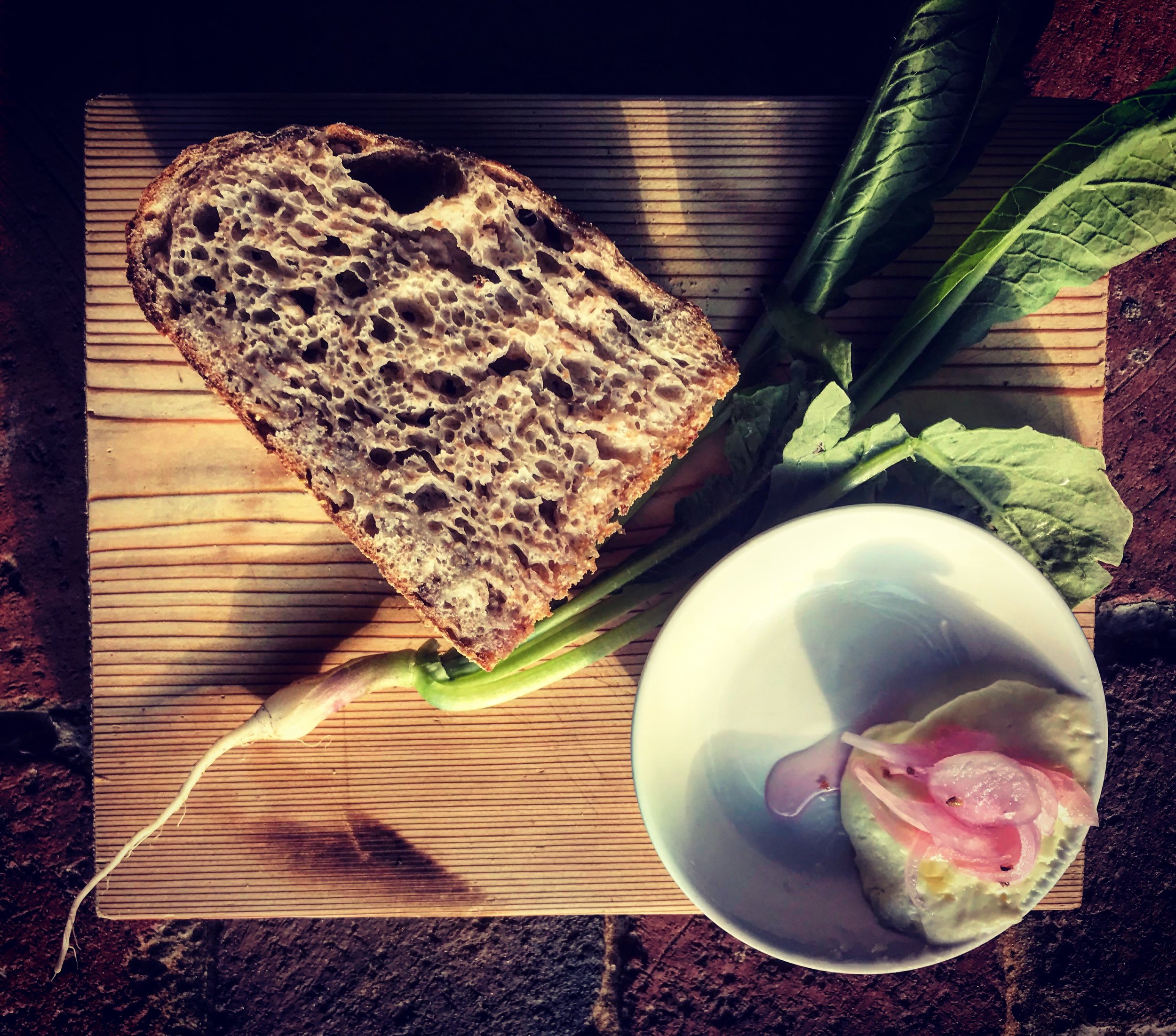 Double fermented, smoked rye porridge sourdough. House whipped butter and rendered lard with pickled onions, Pig roast.