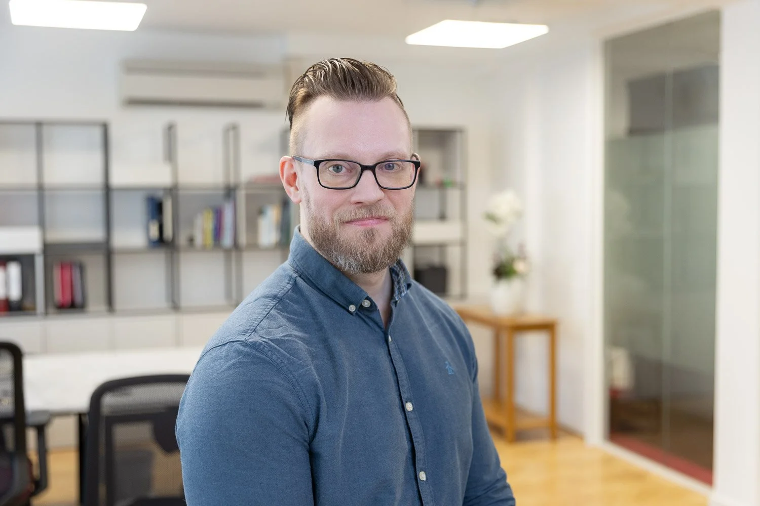 Male employee at corporate team headshots photographed on location in London office wearing a blue shirt 