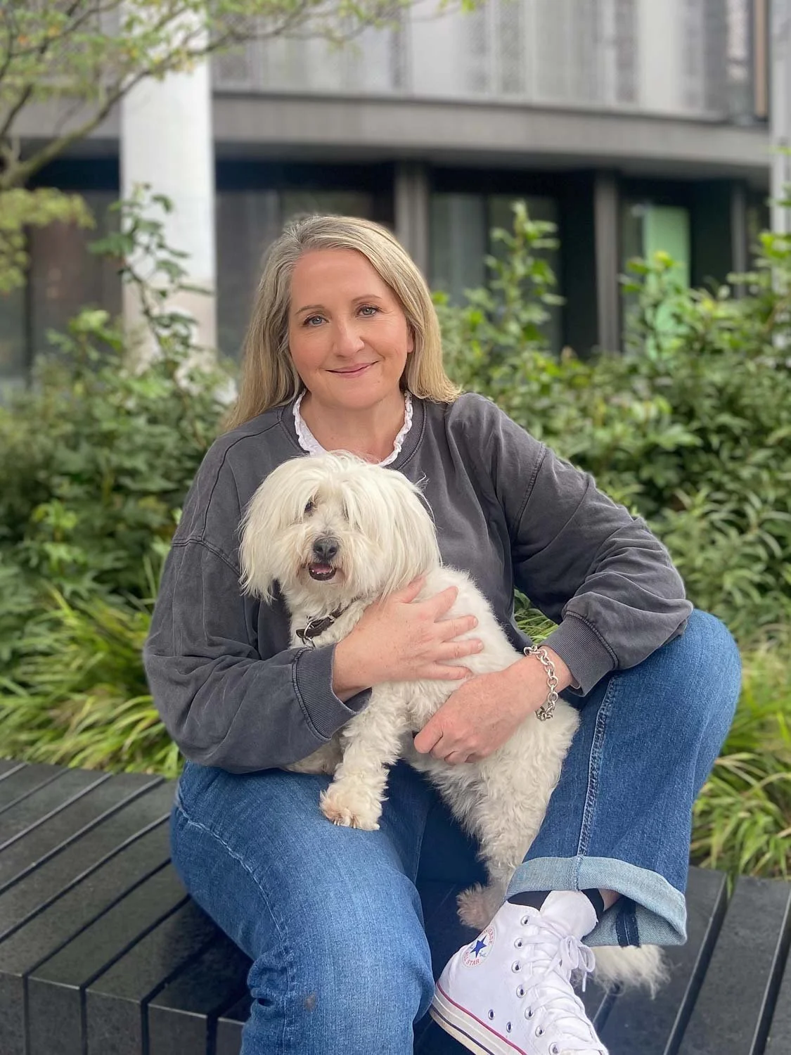 Lady sitting outside with white dog