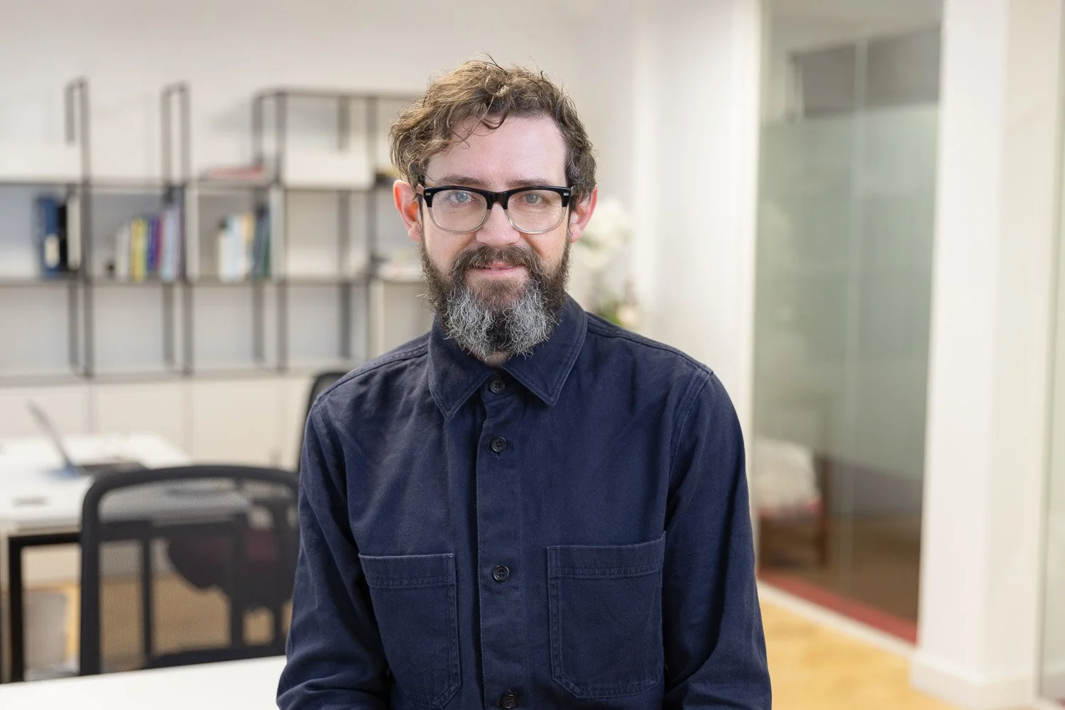 Male employee at corporate team headshot photoshoot wearing a dark shirt 
