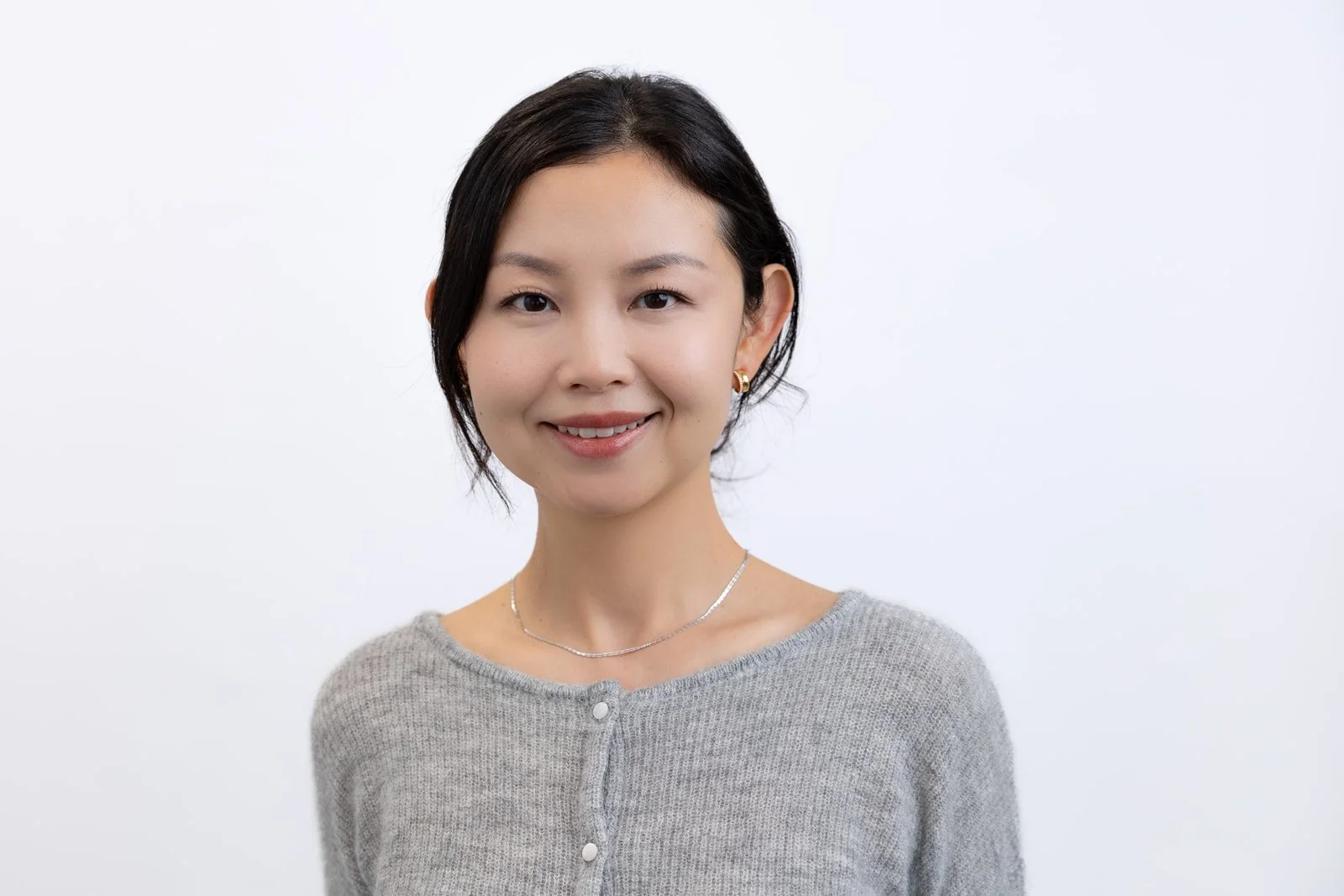 Corporate team headshots showing female team member against white backdrop looking confidently into the camera 