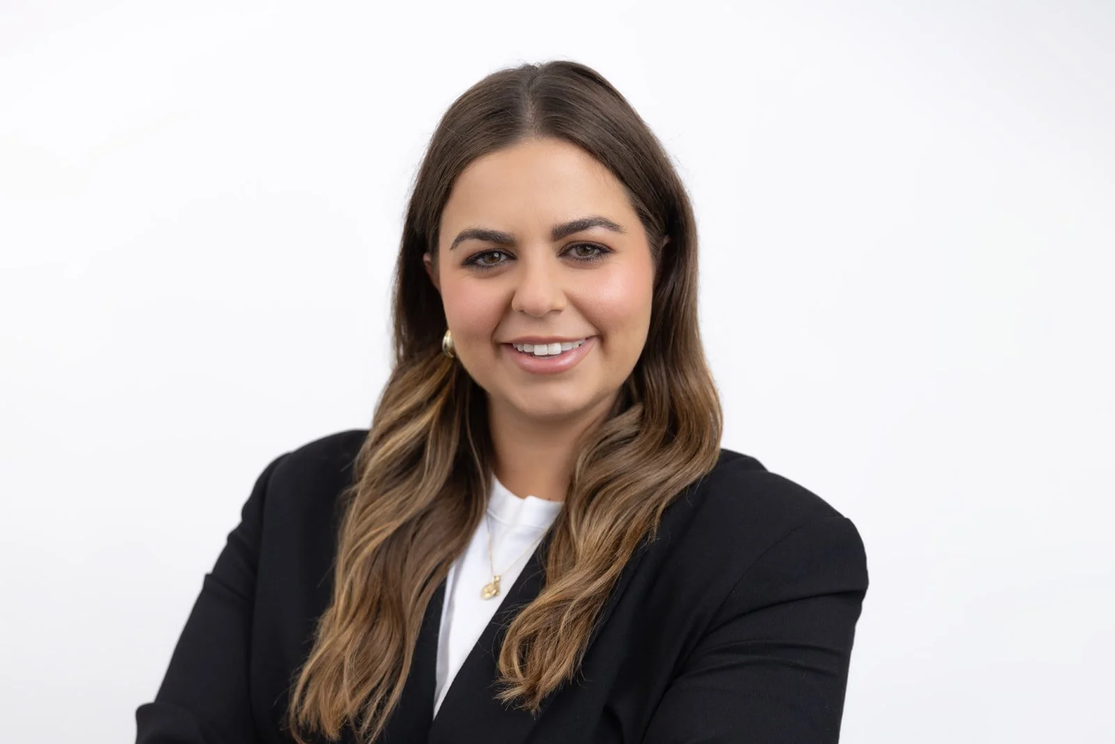 Corporate headshot session for company team in London with female team member wearing a dark jacket against a white backdrop