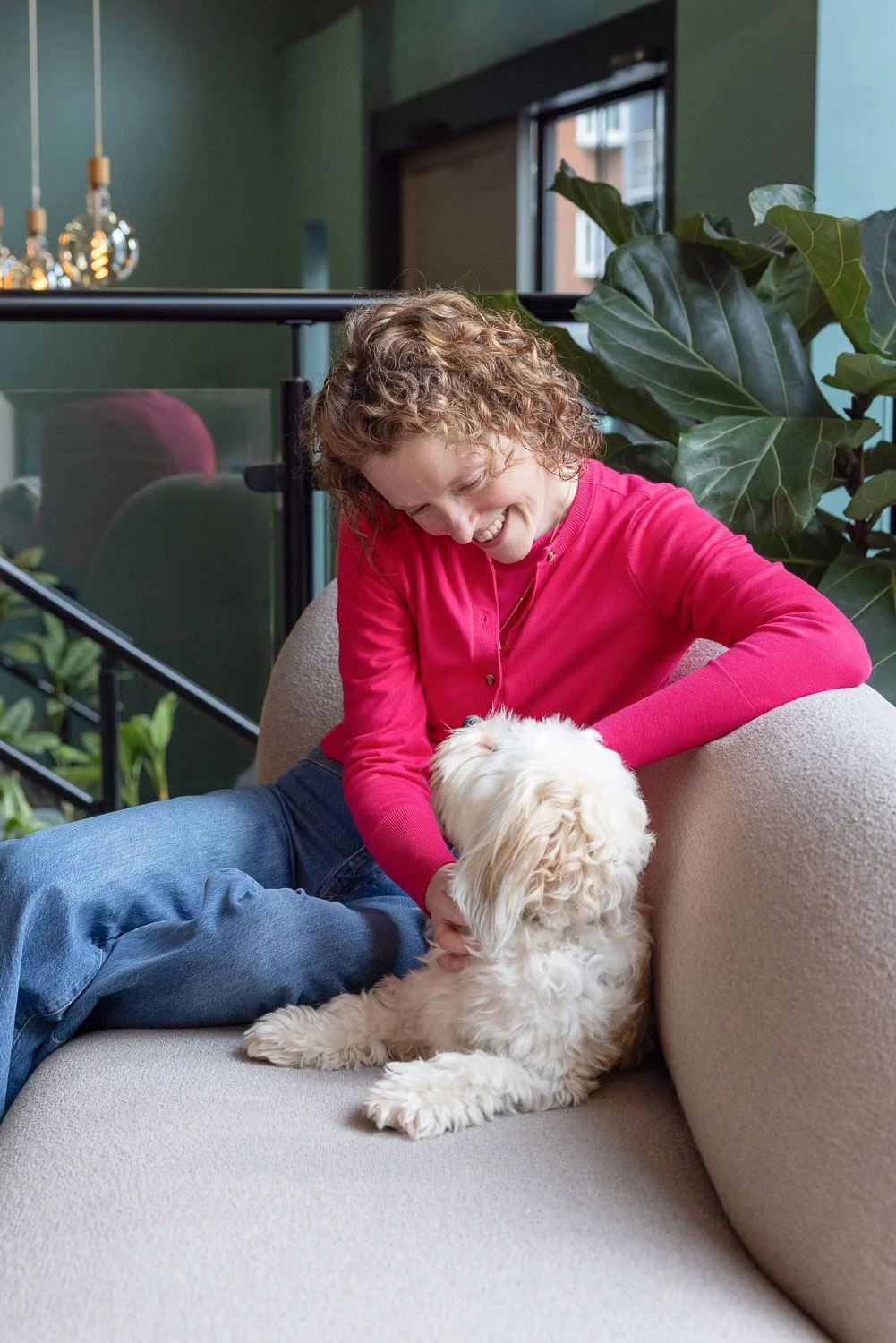 Candid moment during a personal branding session showing a relaxed and natural pose of a female business owner and her dog