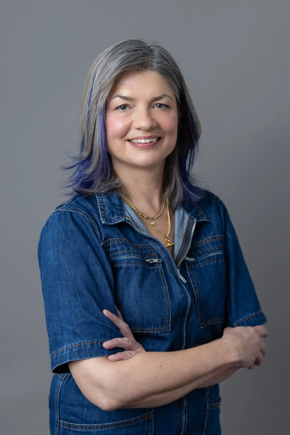 Corporate headshot session for company team in London showing female employee wearing a denim blue outfit and crossed arms 