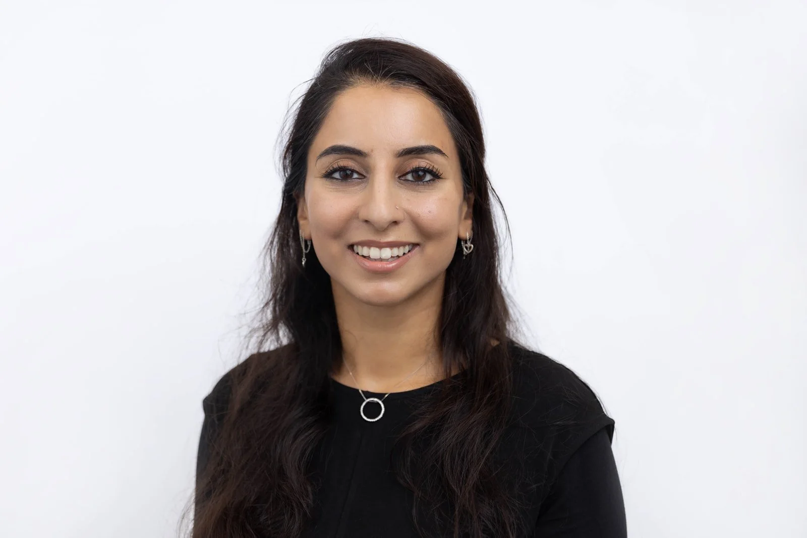 Natural Corporate team headshots photographed against a white backdrop showing a female team member looking relaxed and confidently at the camera