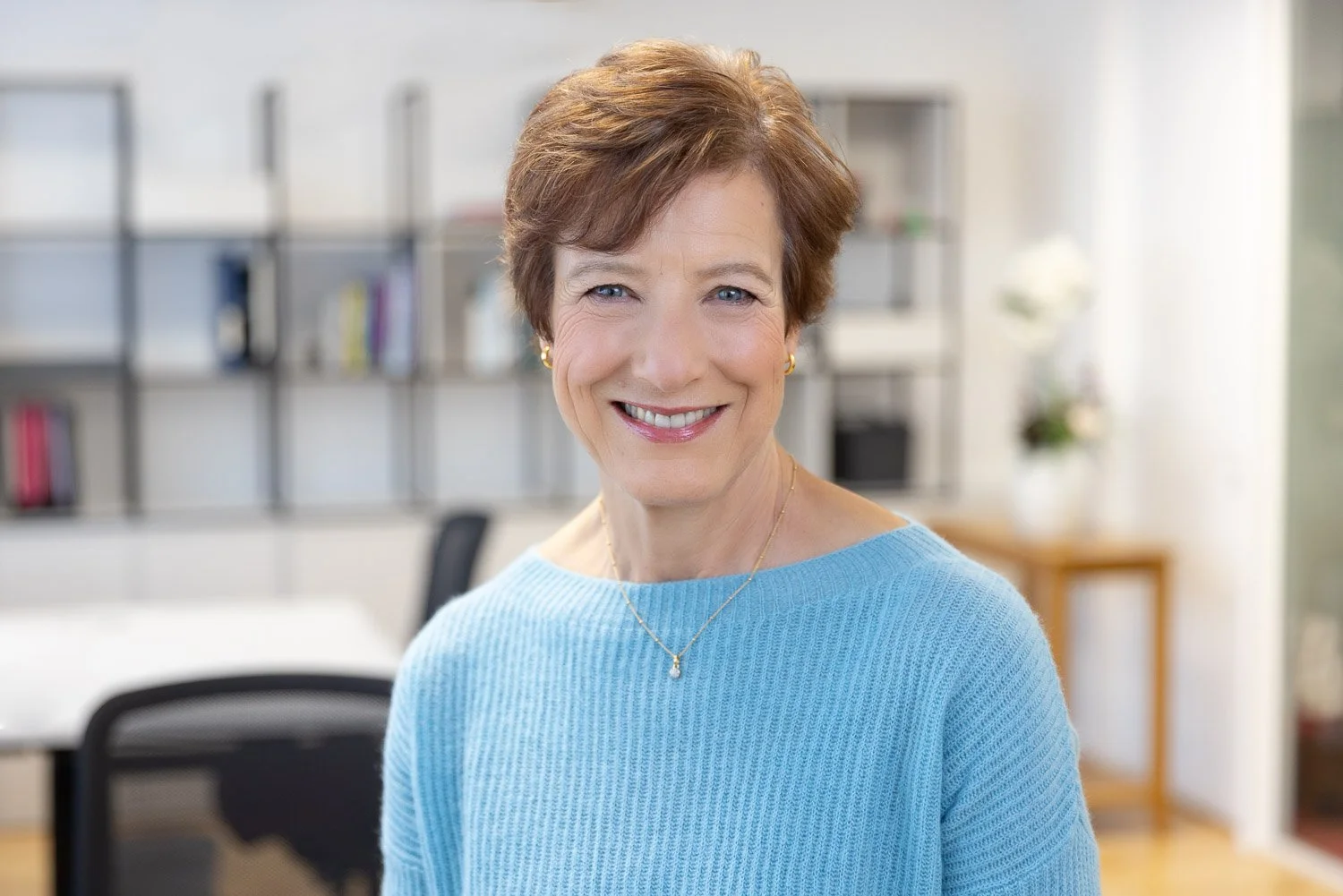 Female employee photographed for a corporate team headshot photoshoot with office loaction in background 