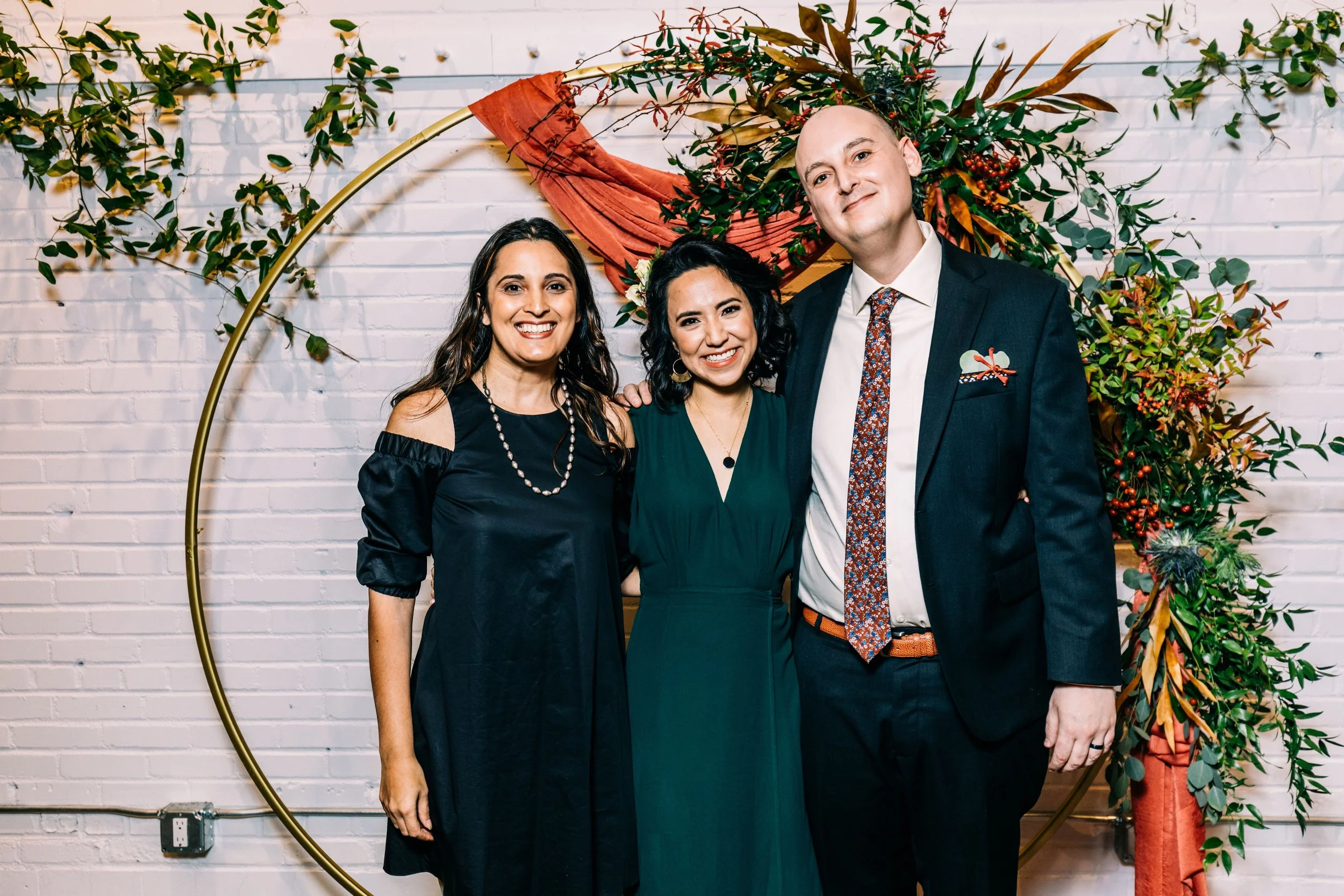 Reena of Kahani Events standing with the couple in front of their wedding arch.