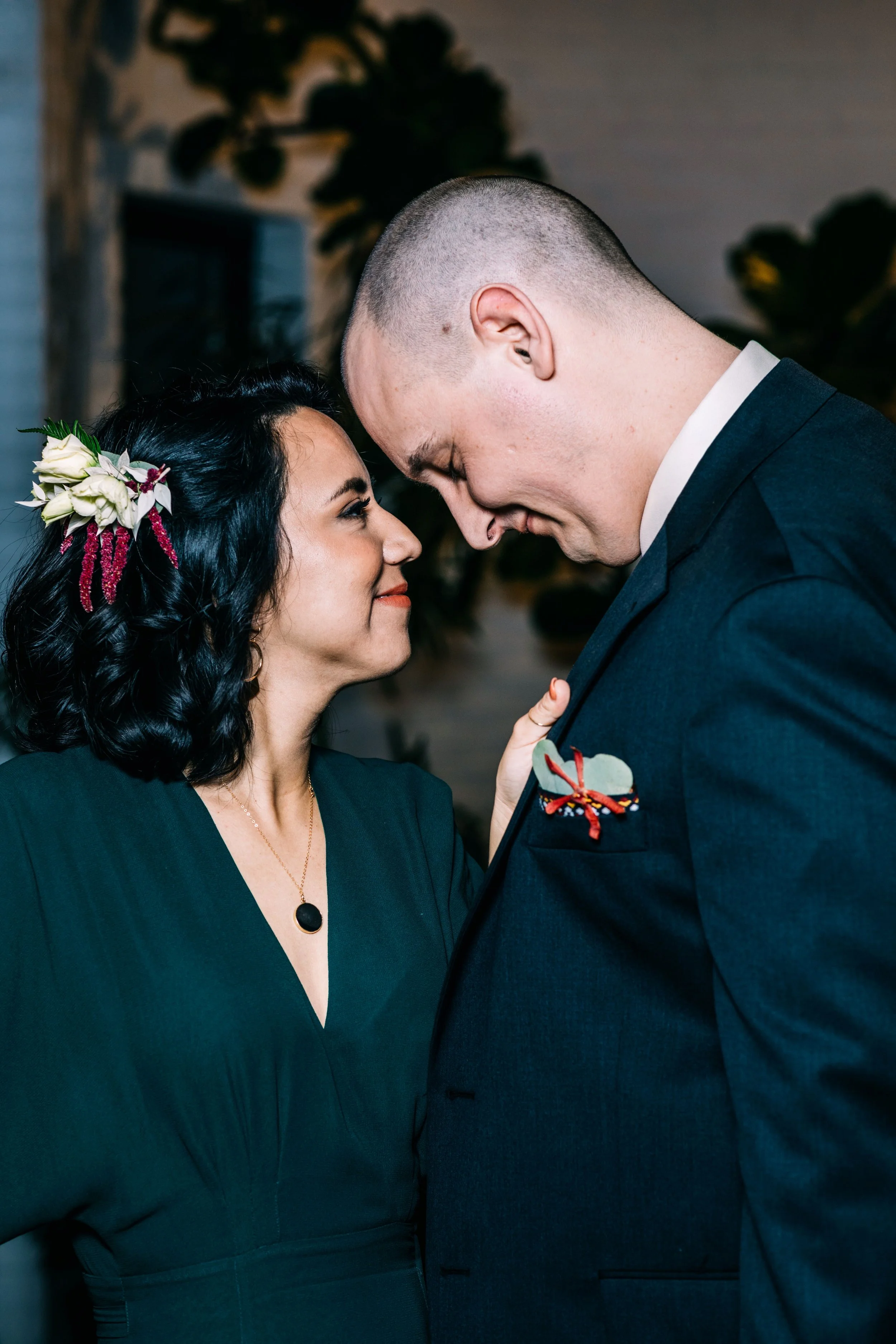 The couple Lorena & Corey standing face to face. You can see the detail on the floral hairpiece and Corey's boutonniere
