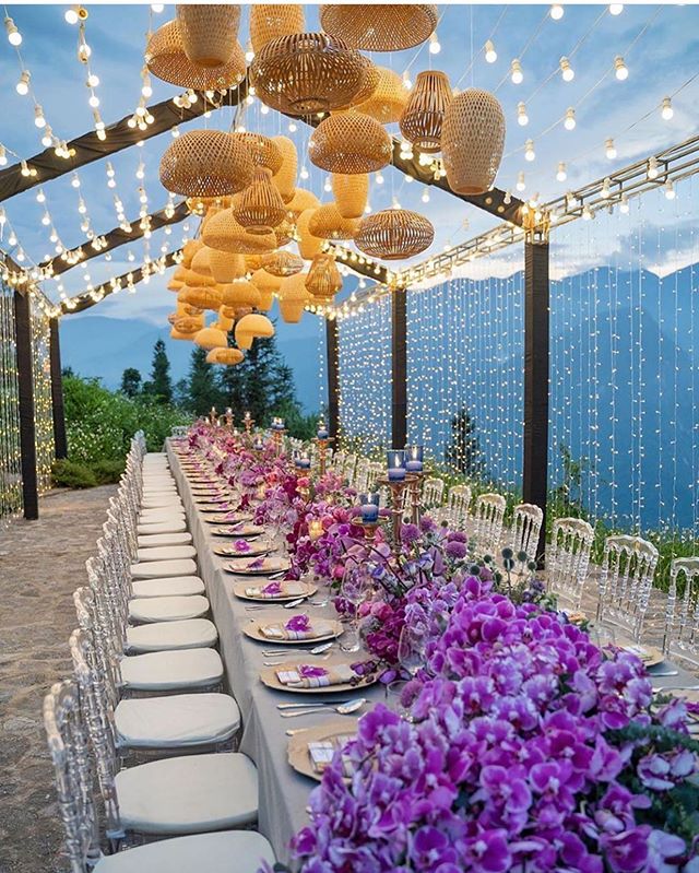 When outdoor decor is taken to a whole new level with purple orchids, gold straw fixtures, and hundreds of string lights. #weddingdecor #weddinginspiration #outdoorwedding