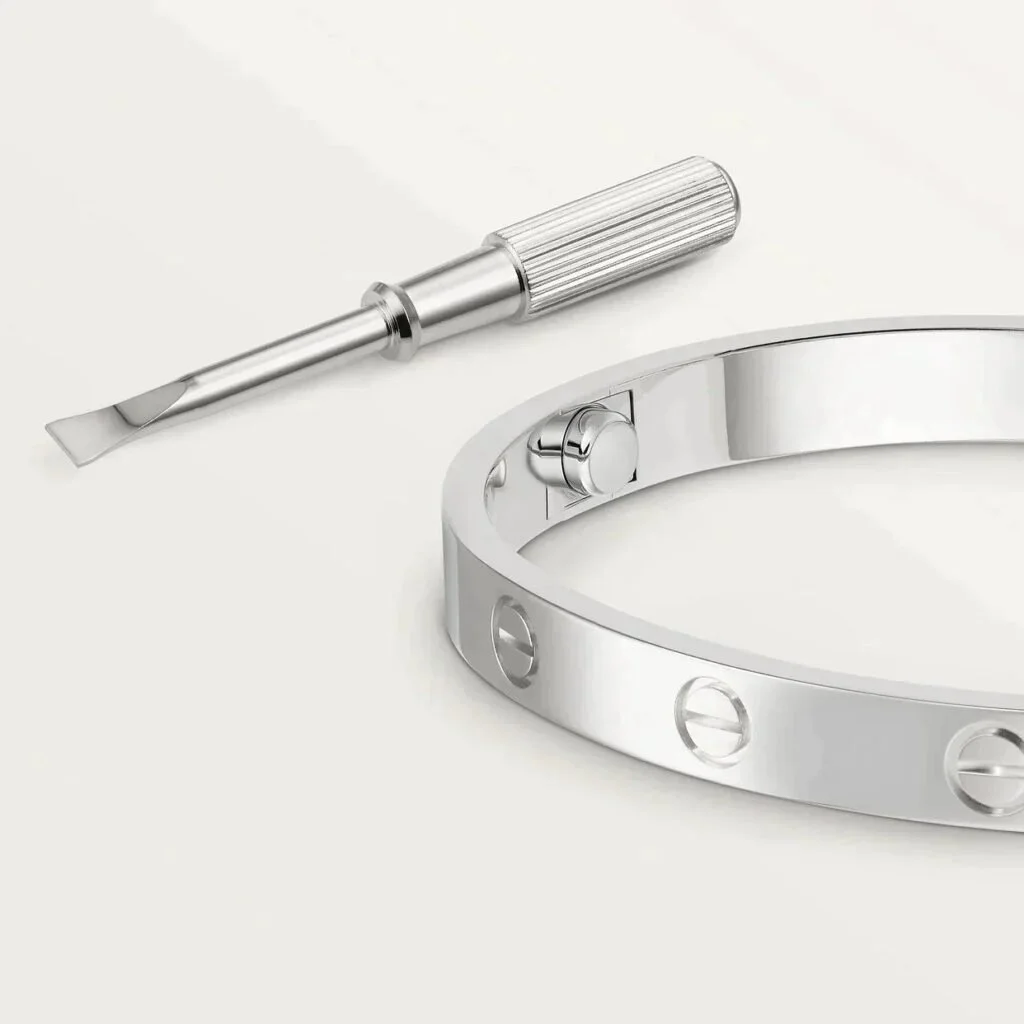 Silver bangle bracelet with screwdriver on light background