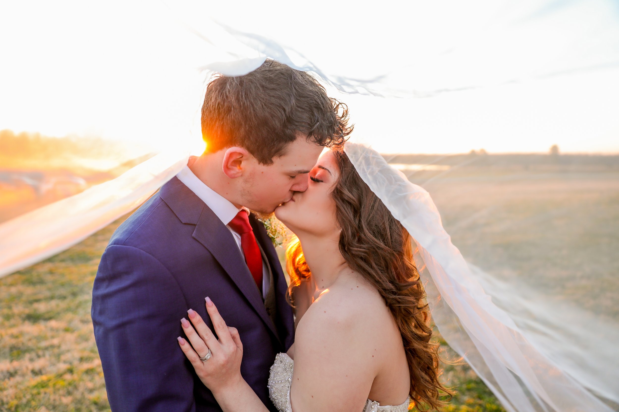 couple kissing outside barn wedding venue in eastern NC 