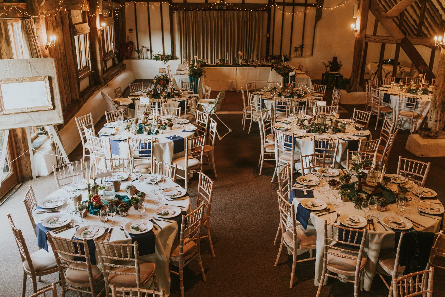 Round wedding tables in barn with flowers