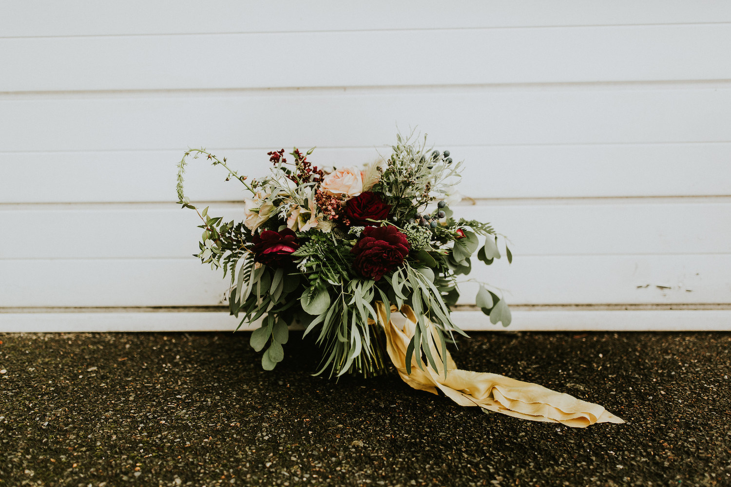 Rustic wedding bouquet by white wall 