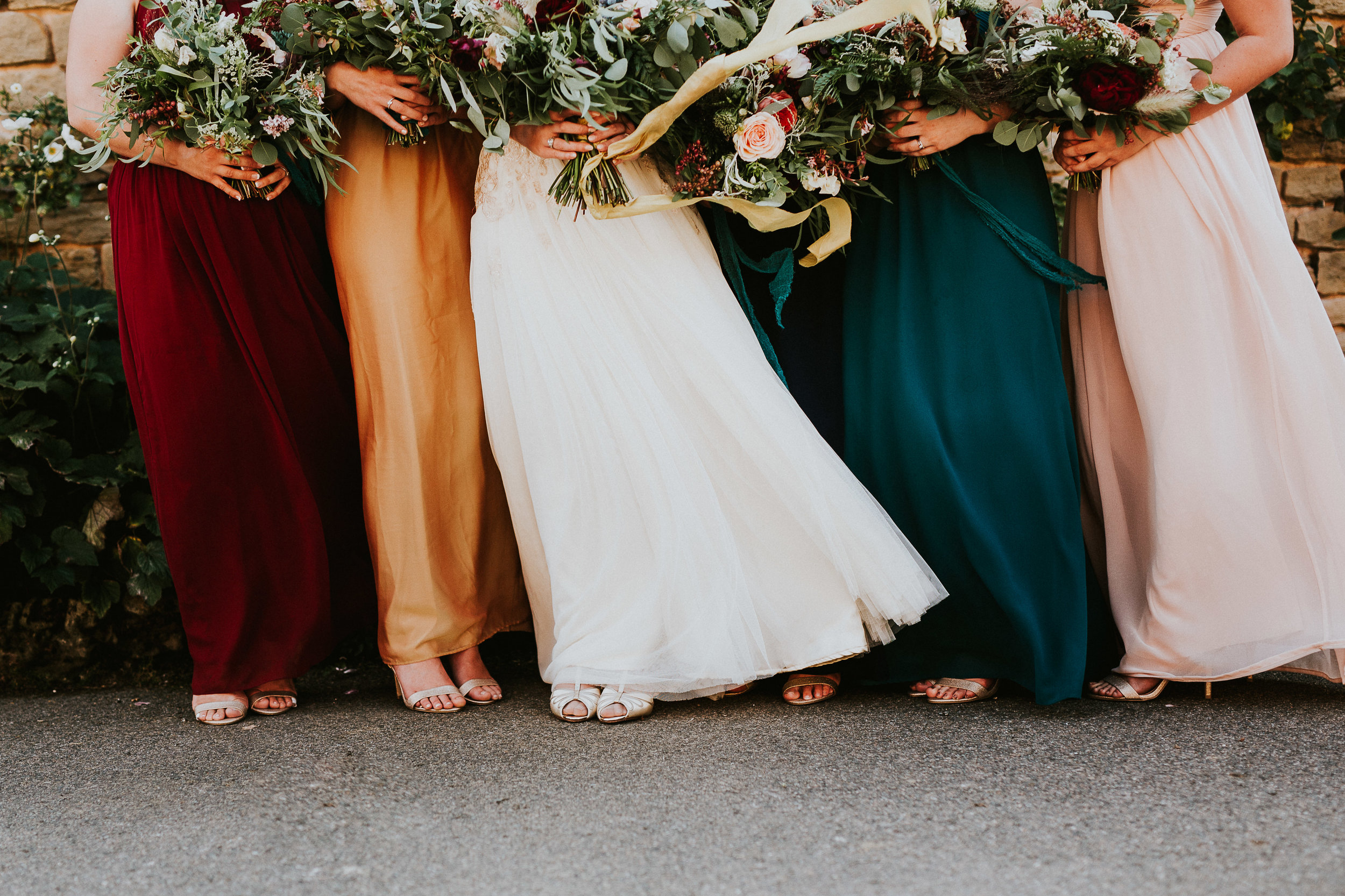 Colourful bridesmaids dresses with rustic woodland bouquets