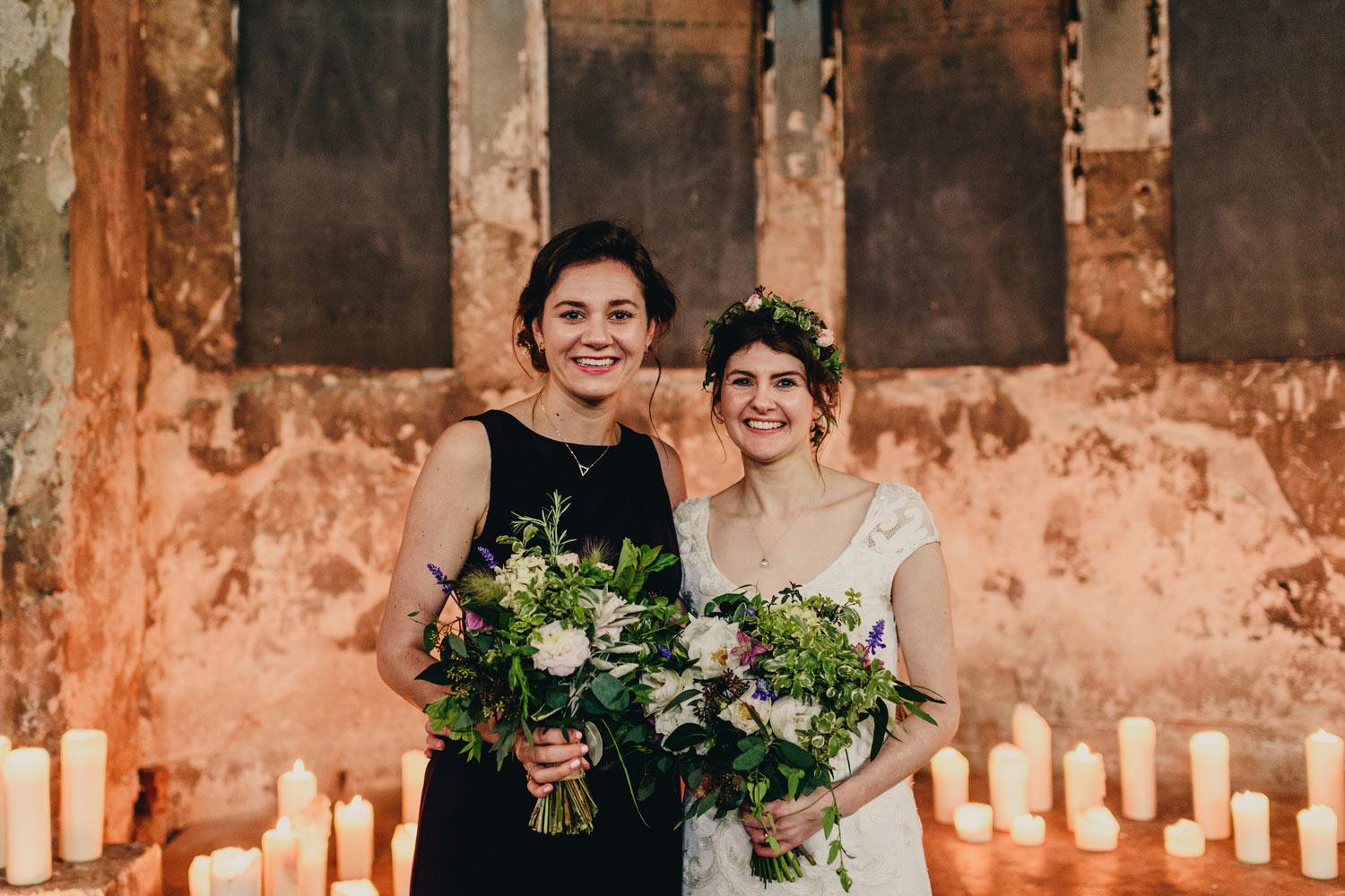 Bride and bridesmaid with flowers at altar in Asylum chapel 