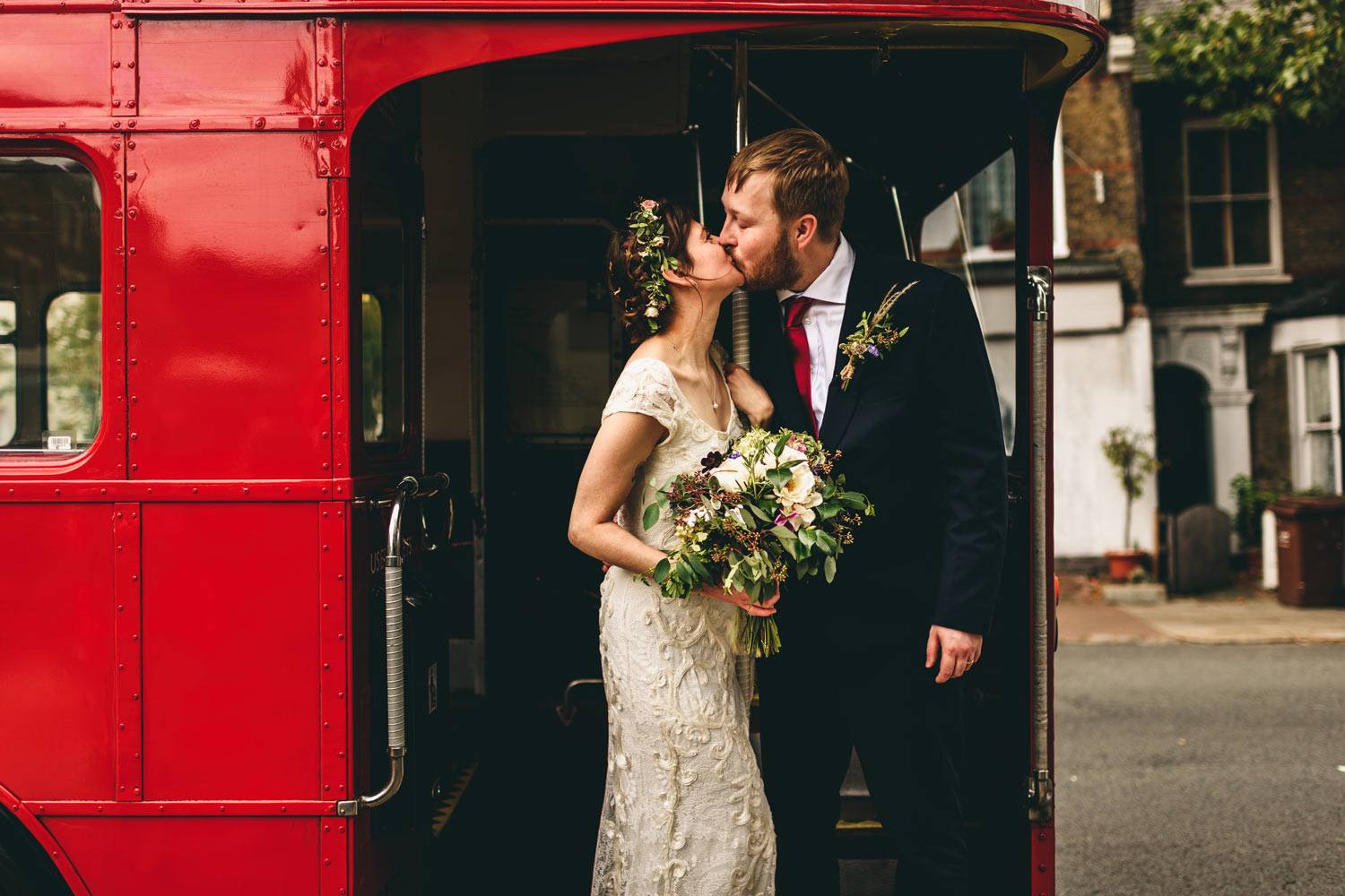 Bride and groom on London bus with flowers
