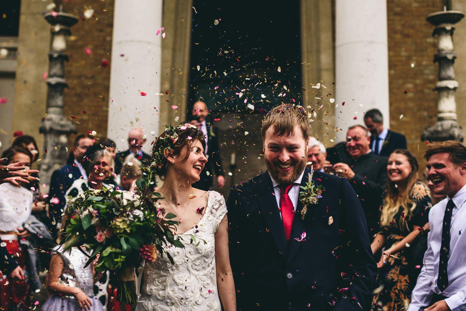 Bride and groom leaving Asylum Chapel ceremony with confetti and crowd 