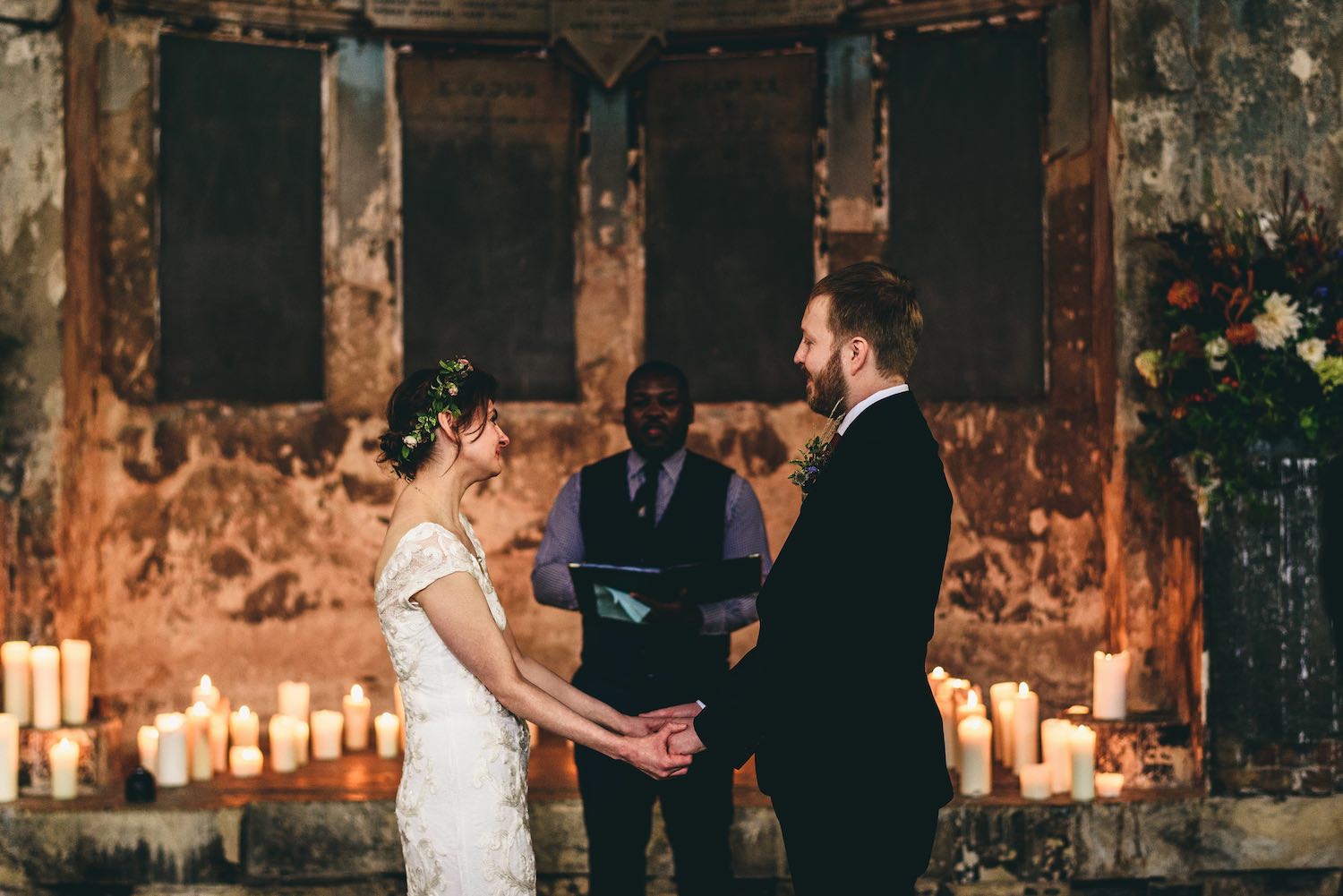 Couple in wedding ceremony holding hands in Asylum chapel