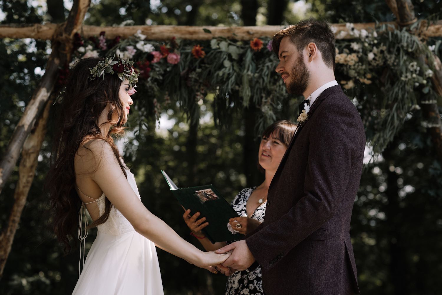 Woodland wedding ceremony couple holding hands