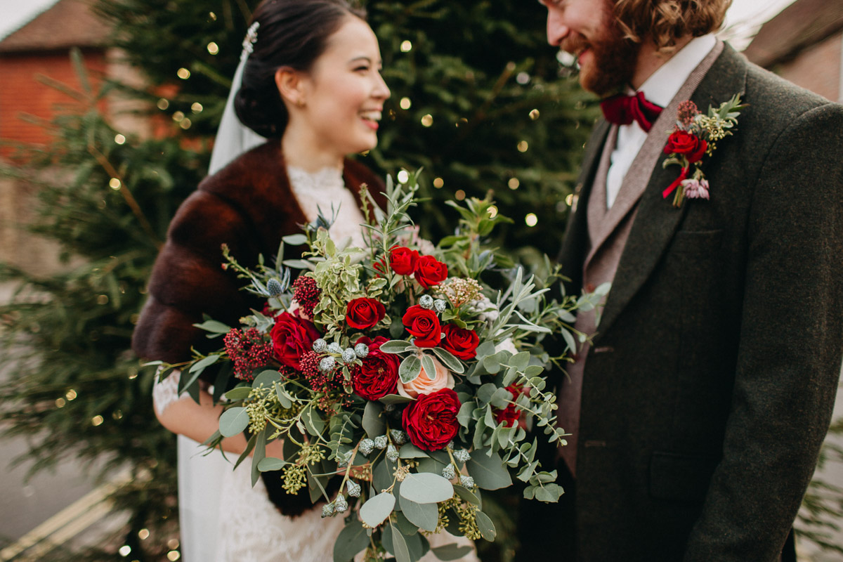 Winter bride and groom with red rose bouquet 