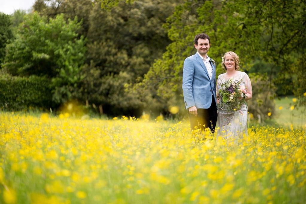Bride and groom in yellow spring meadow 