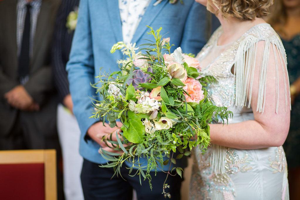 Bride and groom in wedding ceremony with wild bouquet