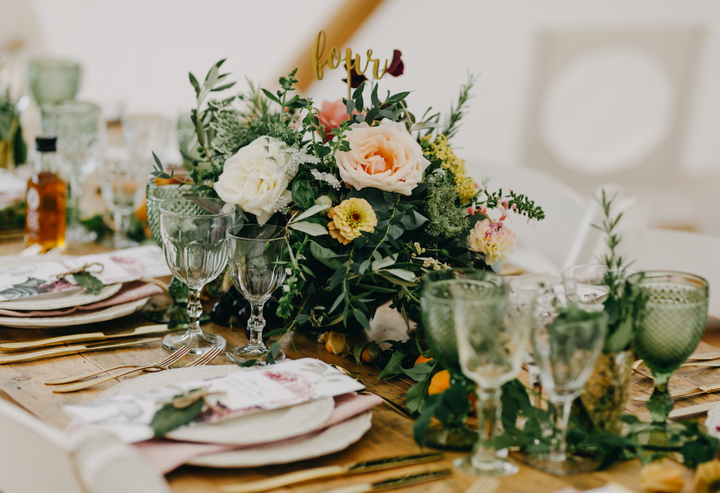 Wedding table centrepiece with roses and wine glasses