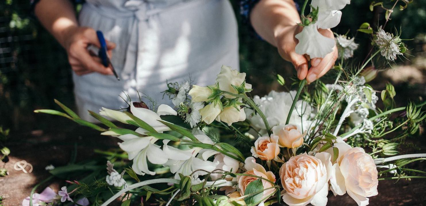 Bea arranging peach roses and white sweet peas in vase