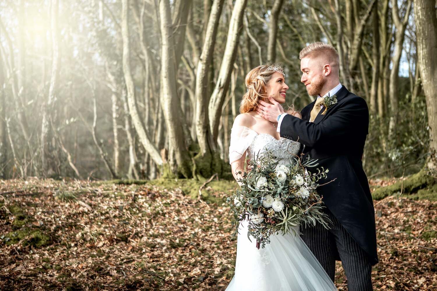 Woodland with bride and groom and bridal flowers posing in winter