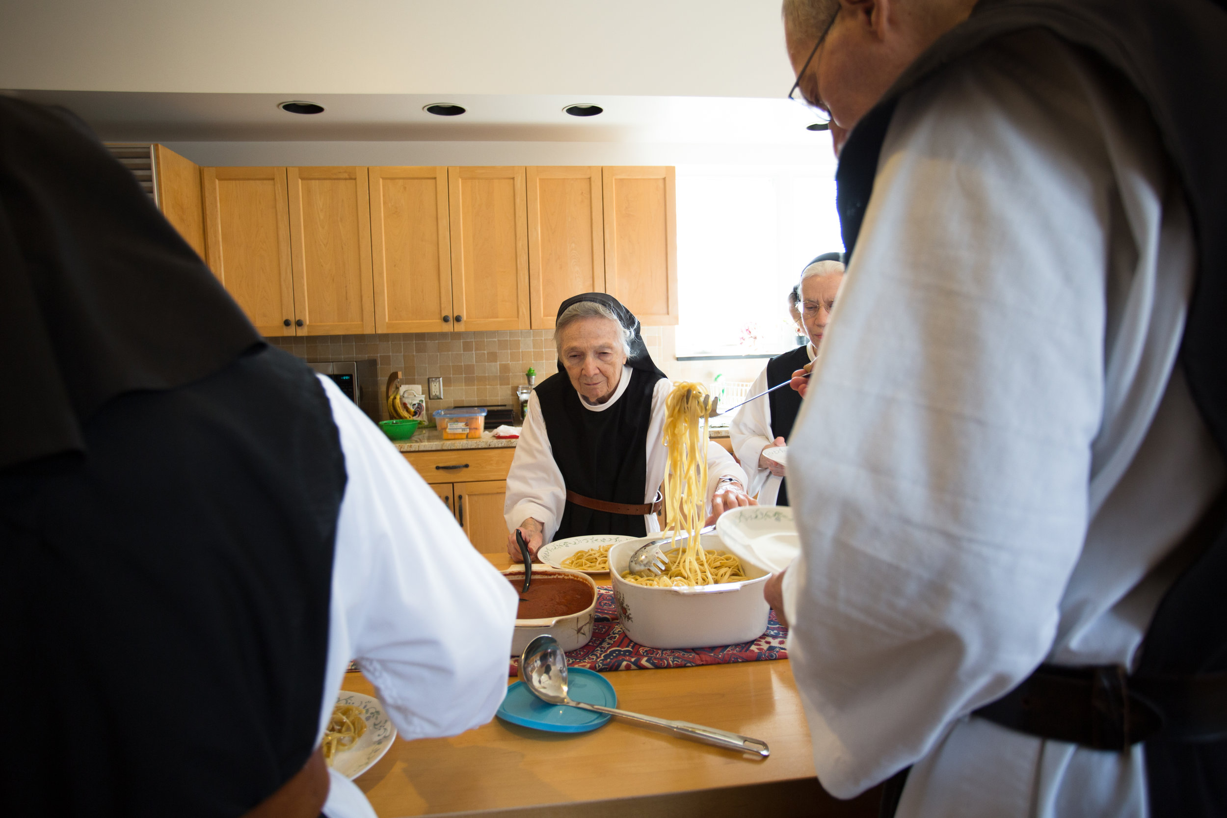  Sister Claire dishes out spaghetti sauce before supper. The sisters eat family style because it is another way to emphasize community and sharing of blessings. Their Gouda cheese is also served on the table. 