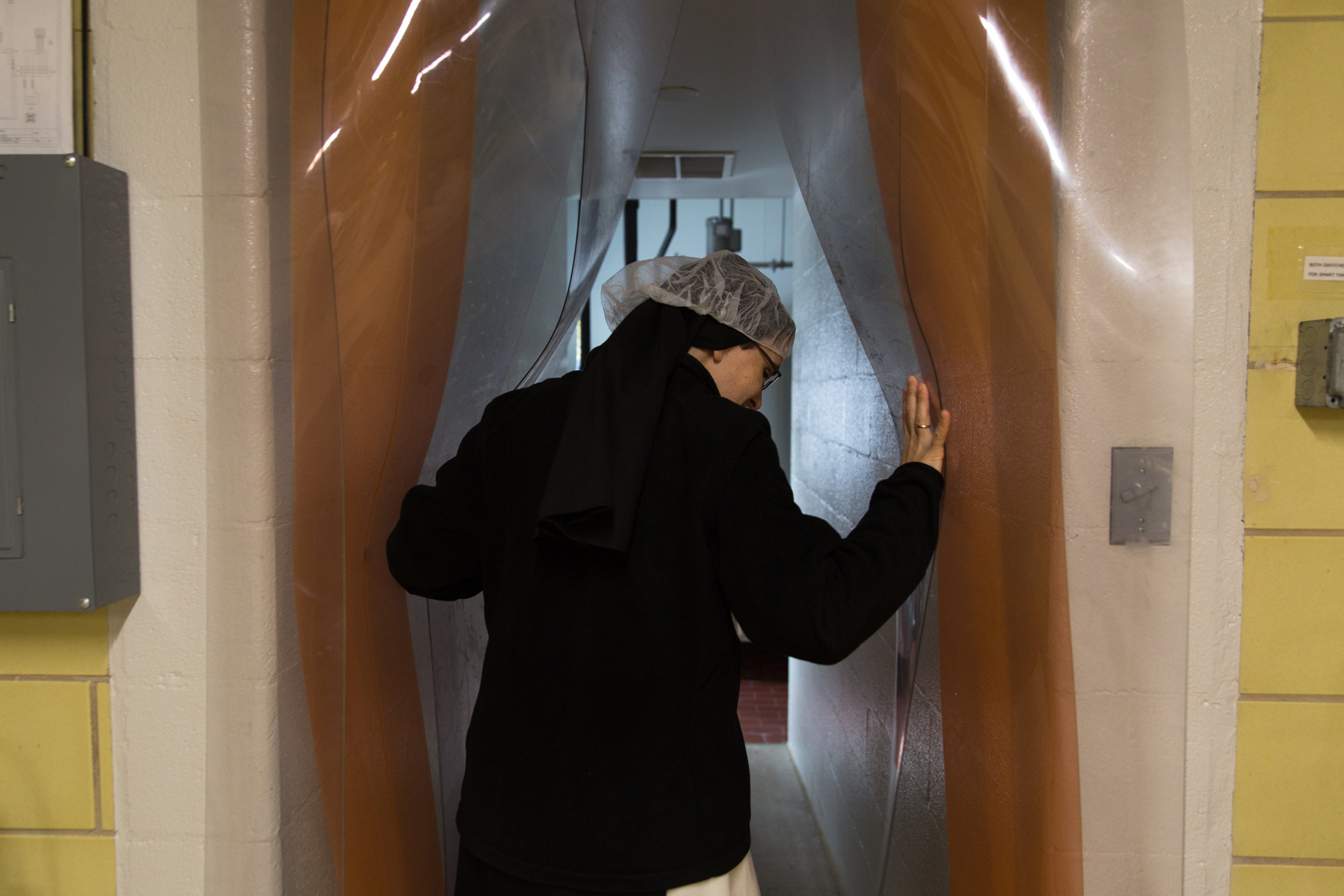  Sister Maria opens the curtains to the milk room at the cheese barn. Thursday’s are cheese days and the sisters arrive in shifts down at the barn starting around 7 a.m.  