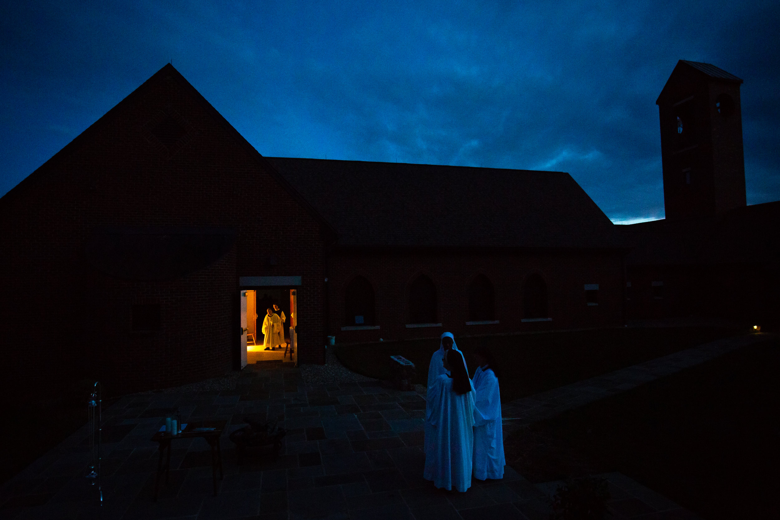  The sisters prepare the patio with candles and a fire for Easter service Saturday evening April 20, 2019 in Crozet, Virginia. Once the guests arrive this begins their procession into the church for Easter mass. 