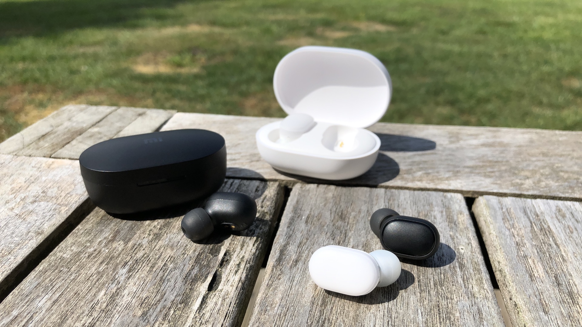 The Redmi Airdots (in black) are smaller than the original AirDots (in white). They also have a physical button instead of a touch button