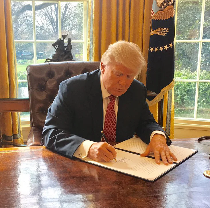 Trump signing Executive Order 13780